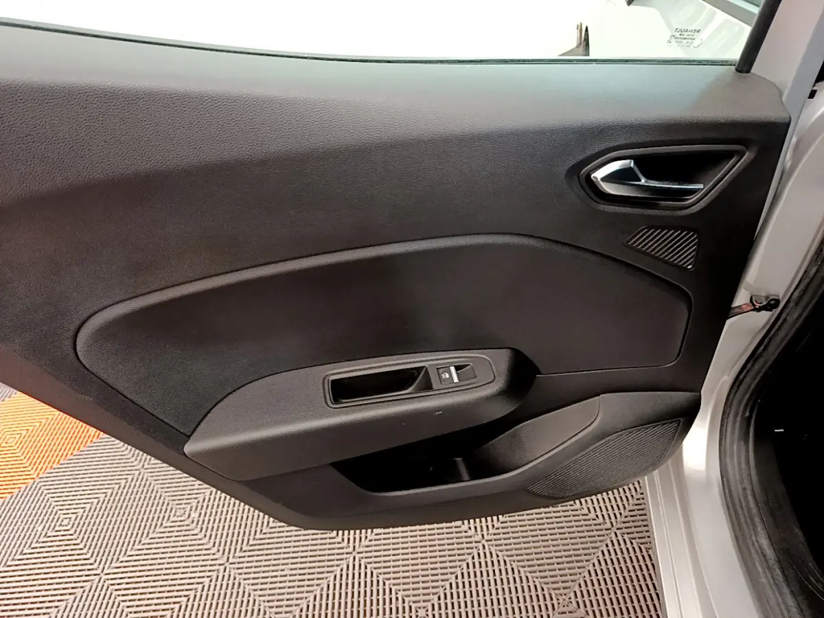 Vue rapprochée de la porte avant gauche gris clair de la Renault Clio Business TCe 100, avec poignée et commande de vitre.