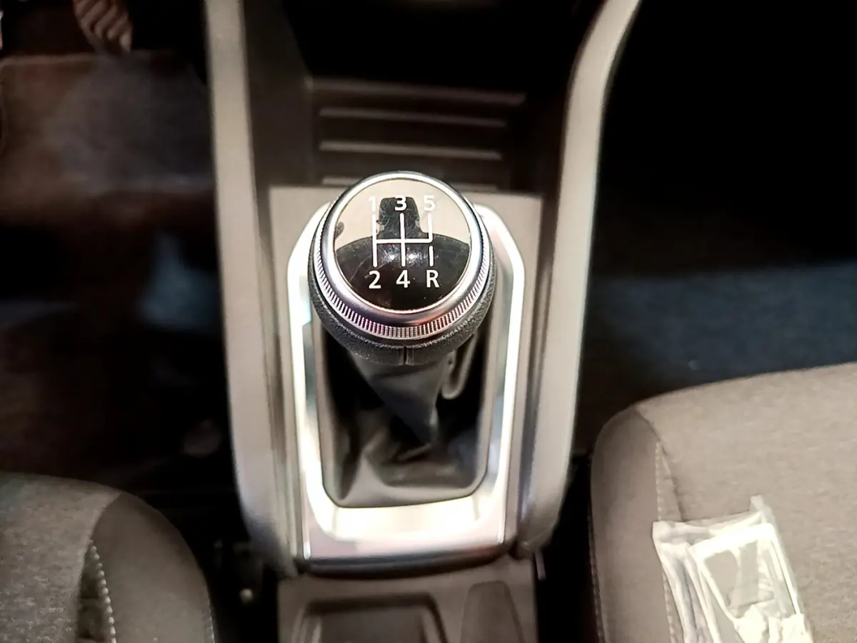 Gros plan sur le levier de vitesses manuel noir et chrome de la Renault Clio Business TCe 100, intérieur gris.