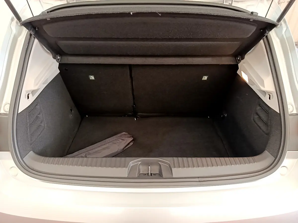 Coffre ouvert vu de dessus d'une Renault Clio Business TCe 100 gris clair, montrant l'espace de rangement vide.