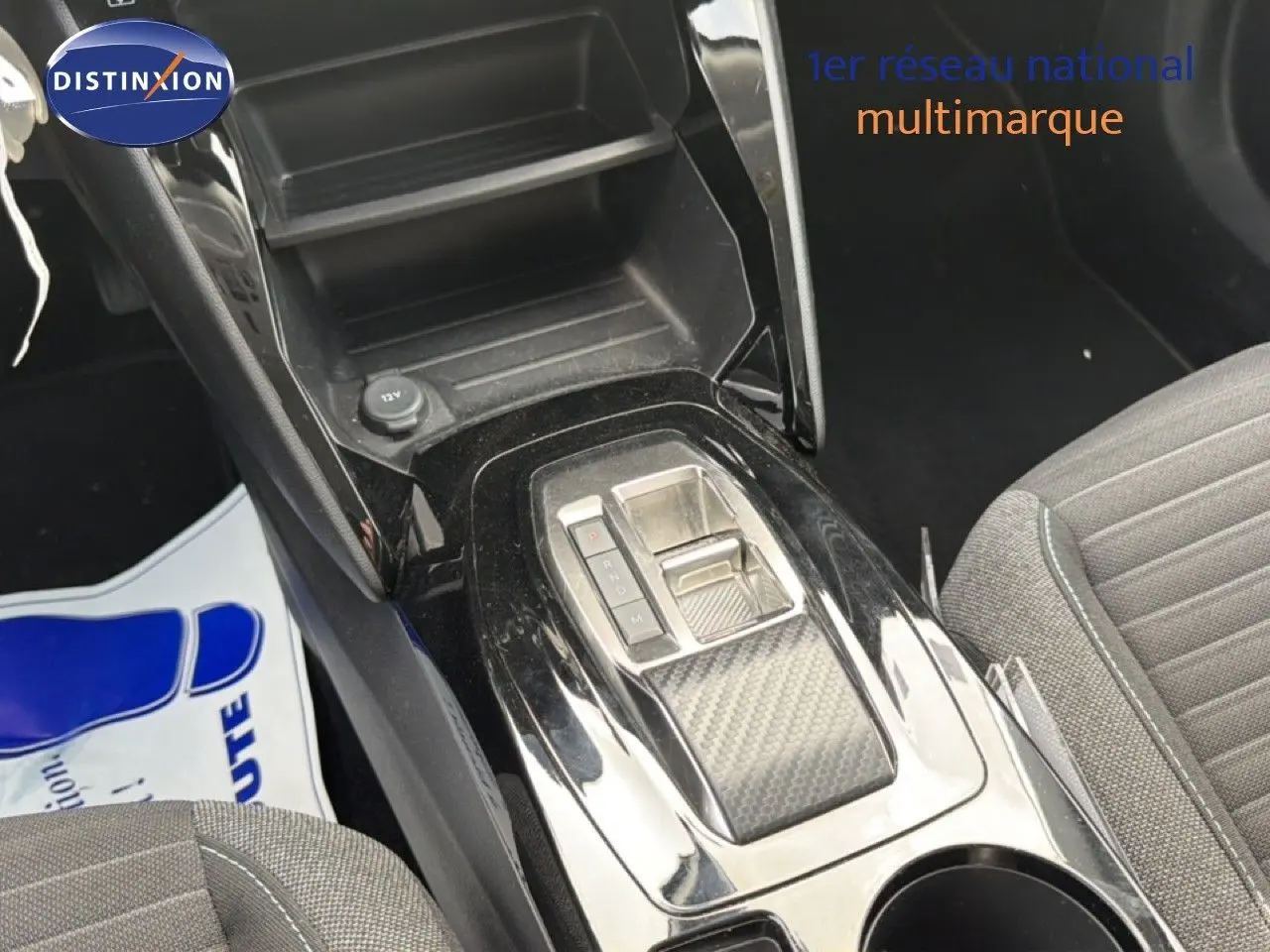 Vue rapprochée de la console centrale noire brillante avec levier de vitesses automatique et siège tissu gris du Peugeot 2008.