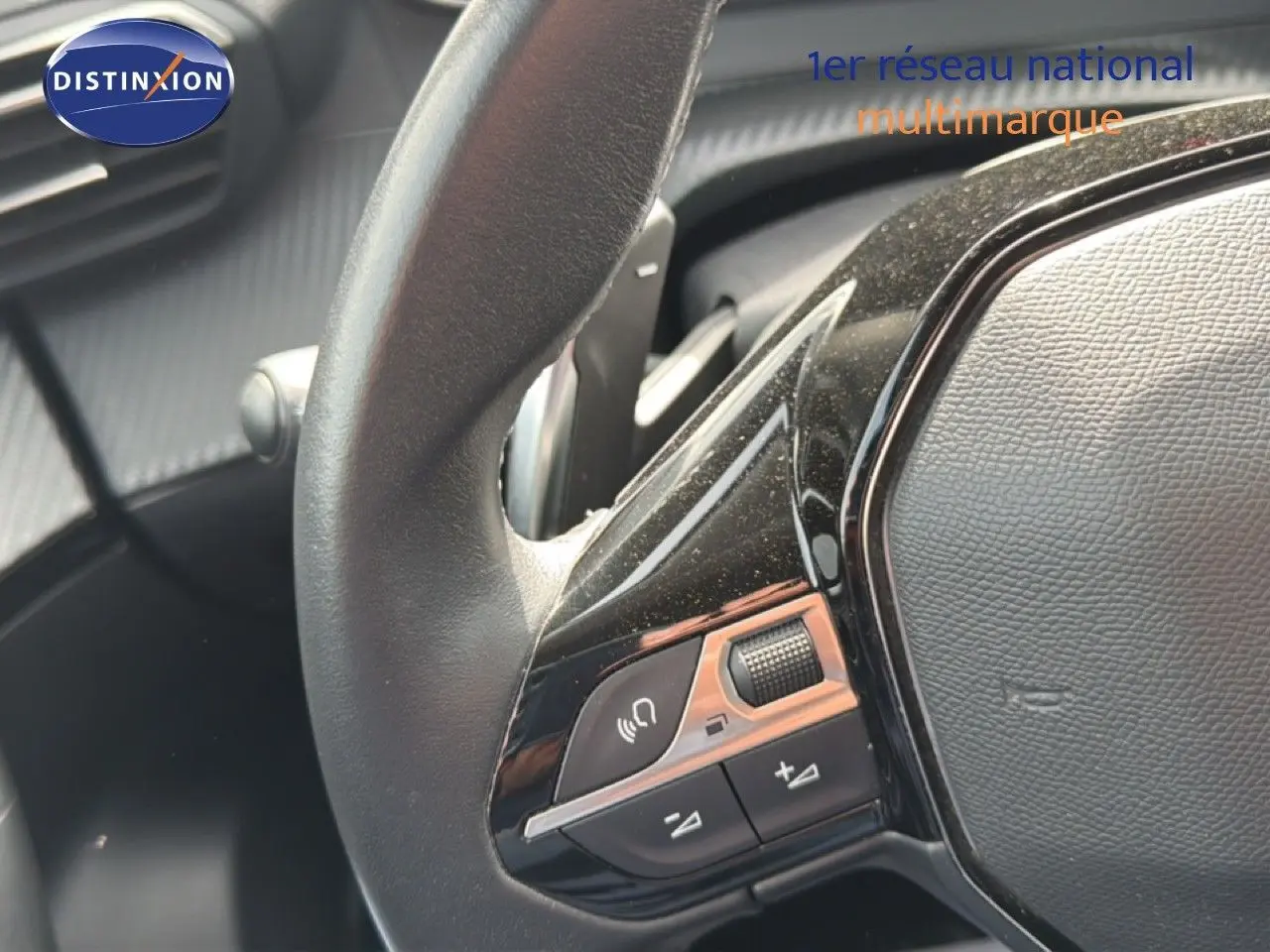 Gros plan sur les commandes gauche du volant noir du Peugeot 2008, soulignant les boutons de volume et de téléphone.