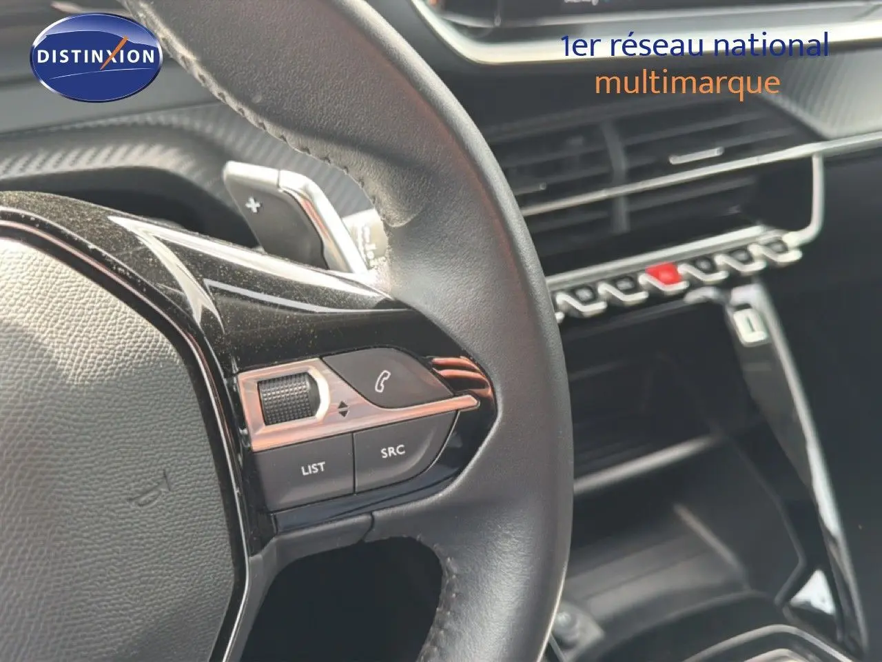 Gros plan sur le volant noir du Peugeot 2008 2022, mettant en valeur les commandes intégrées côté gauche.