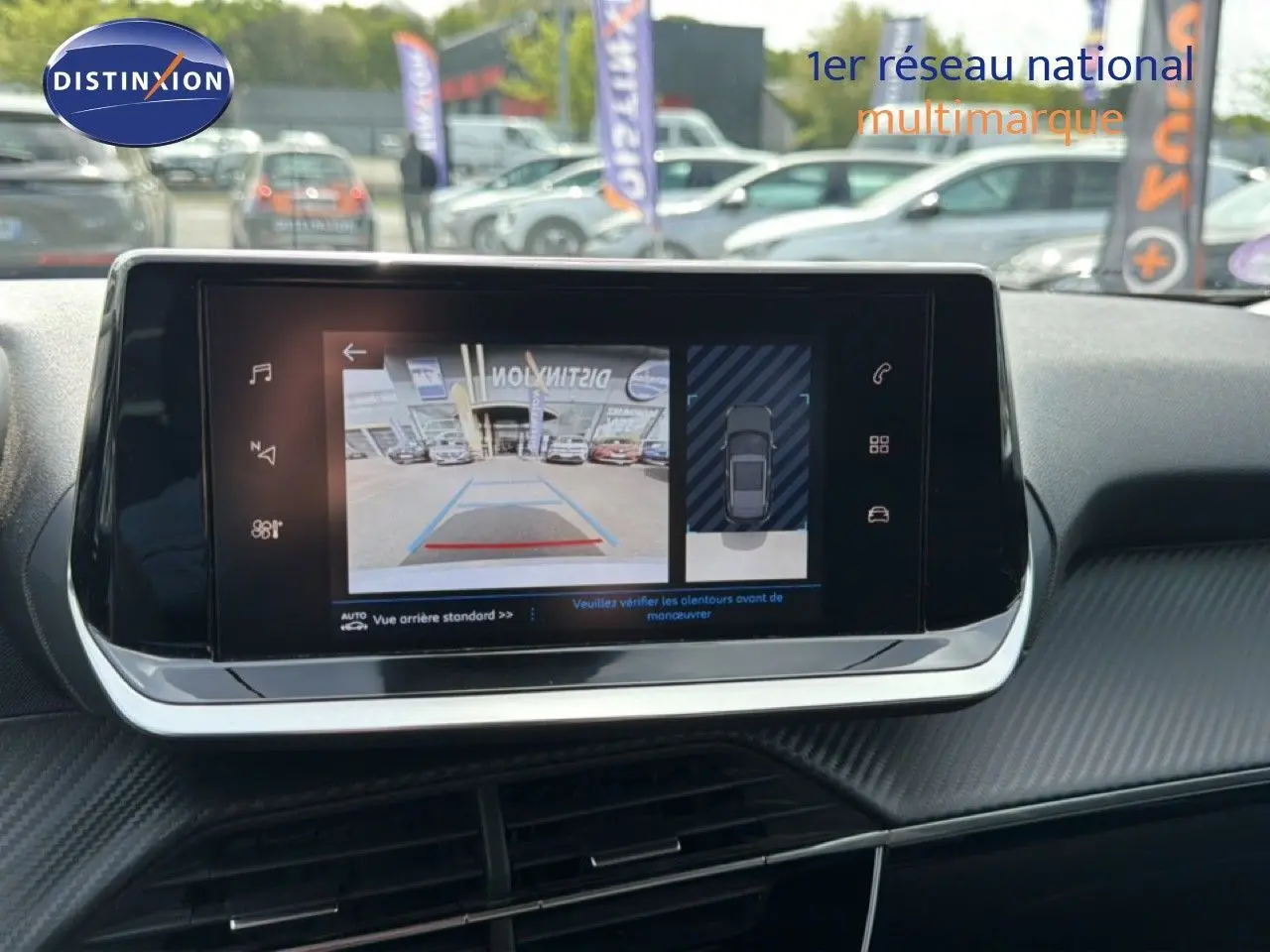Écran tactile intérieur montrant la caméra de recul d'un Peugeot 2008 noir perle métal, vue de face du tableau de bord.