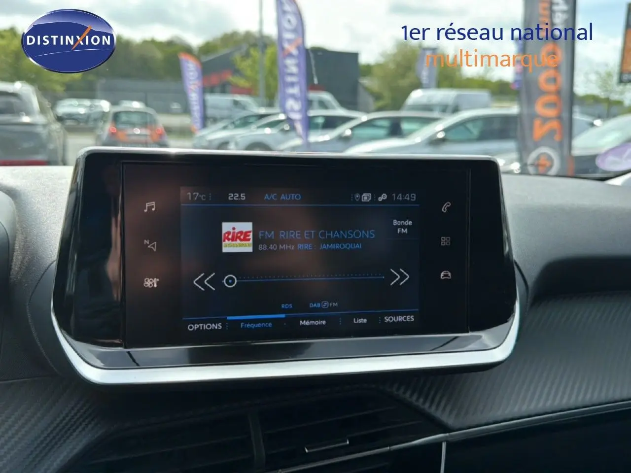 Écran tactile central de la Peugeot 2008 noir perle métal, affichant la radio FM avec interface moderne et finition carbone.