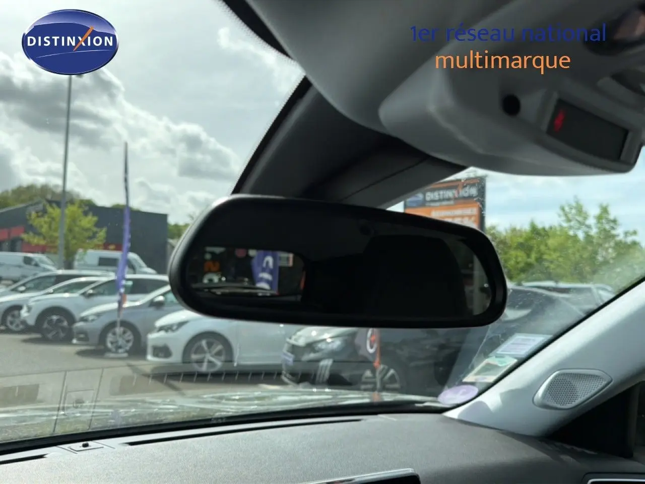 Vue intérieure du rétroviseur central d'un Peugeot 2008 noir perle métal, avec tableau de bord et pare-brise visibles.