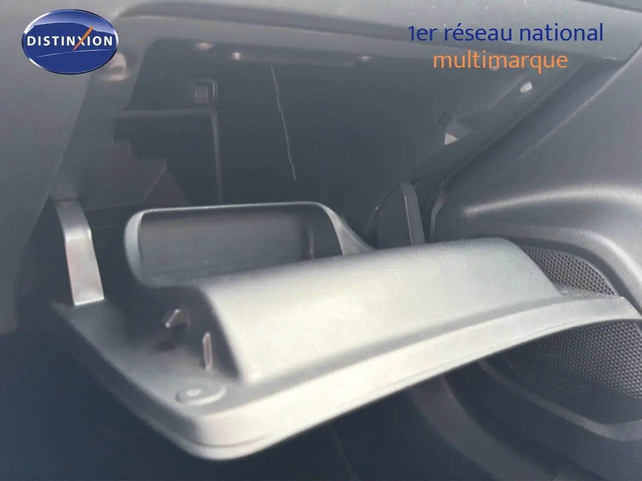 Intérieur du coffre ouvert d’un Peugeot 2008 noir perle métal, vue rapprochée sur le compartiment de rangement.