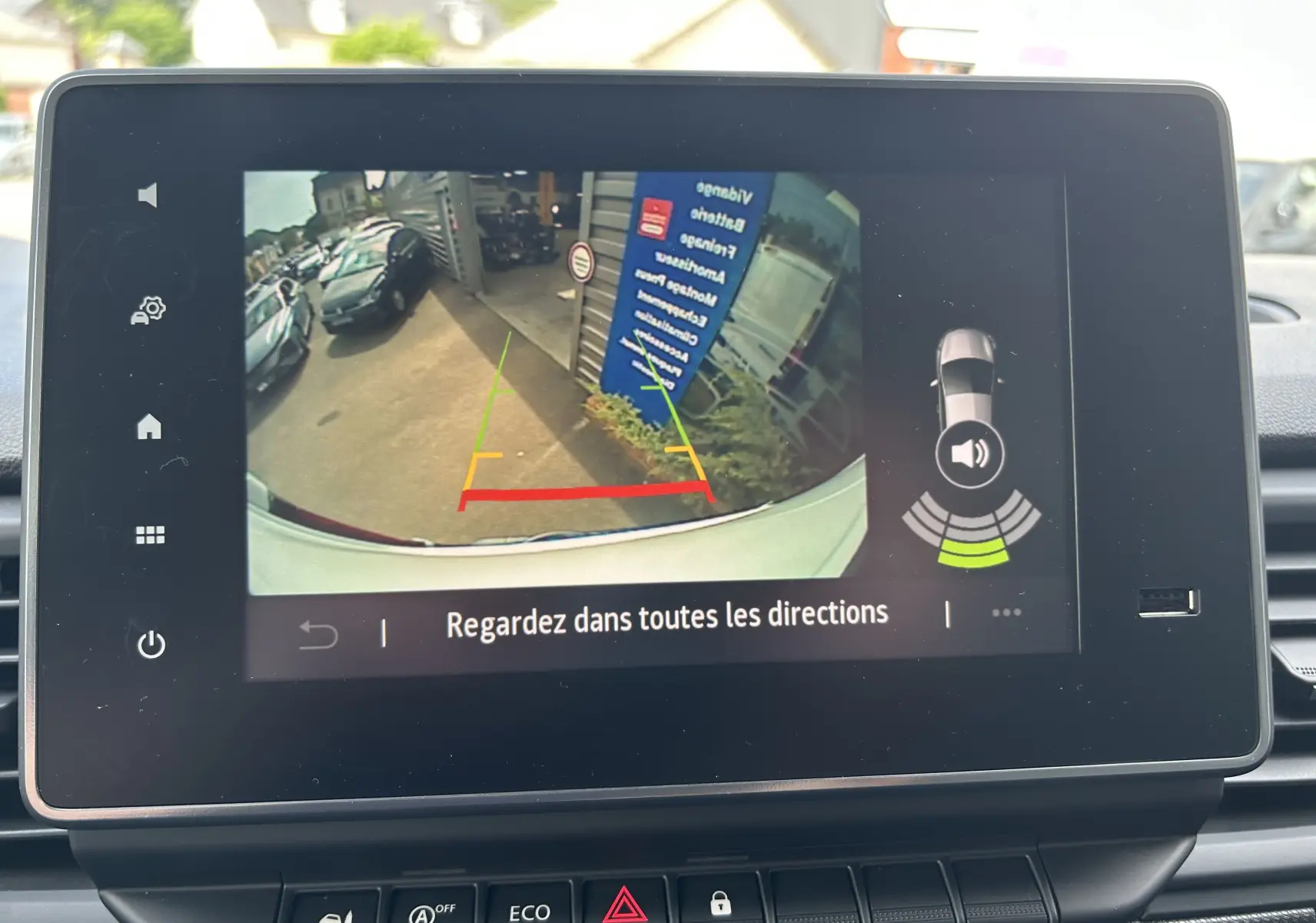 Écran de caméra de recul du Renault Trafic blanc glacier, affichant les lignes de guidage et l'environnement arrière.