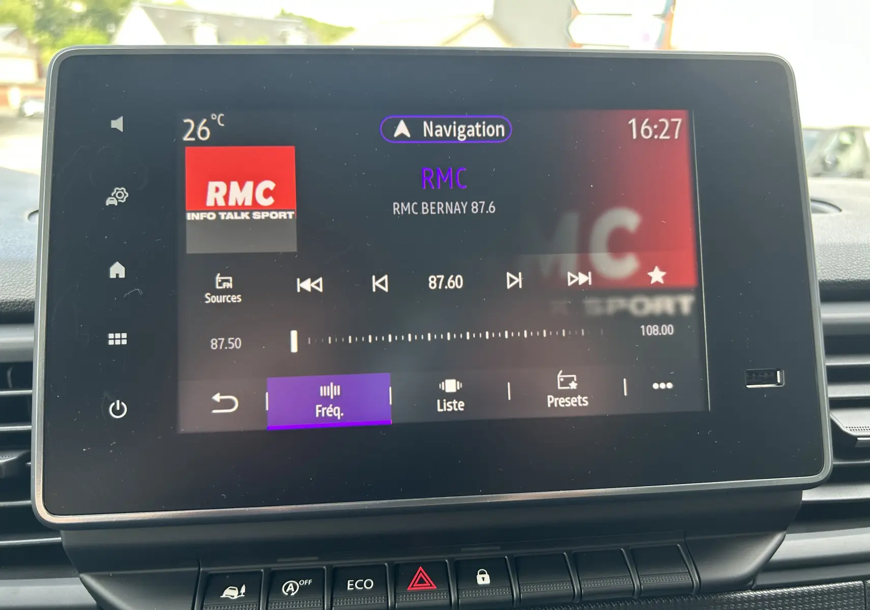 Écran tactile central du Renault Trafic L1H1 2025 affichant la radio RMC à 87.6 FM, avec commandes en bas.
