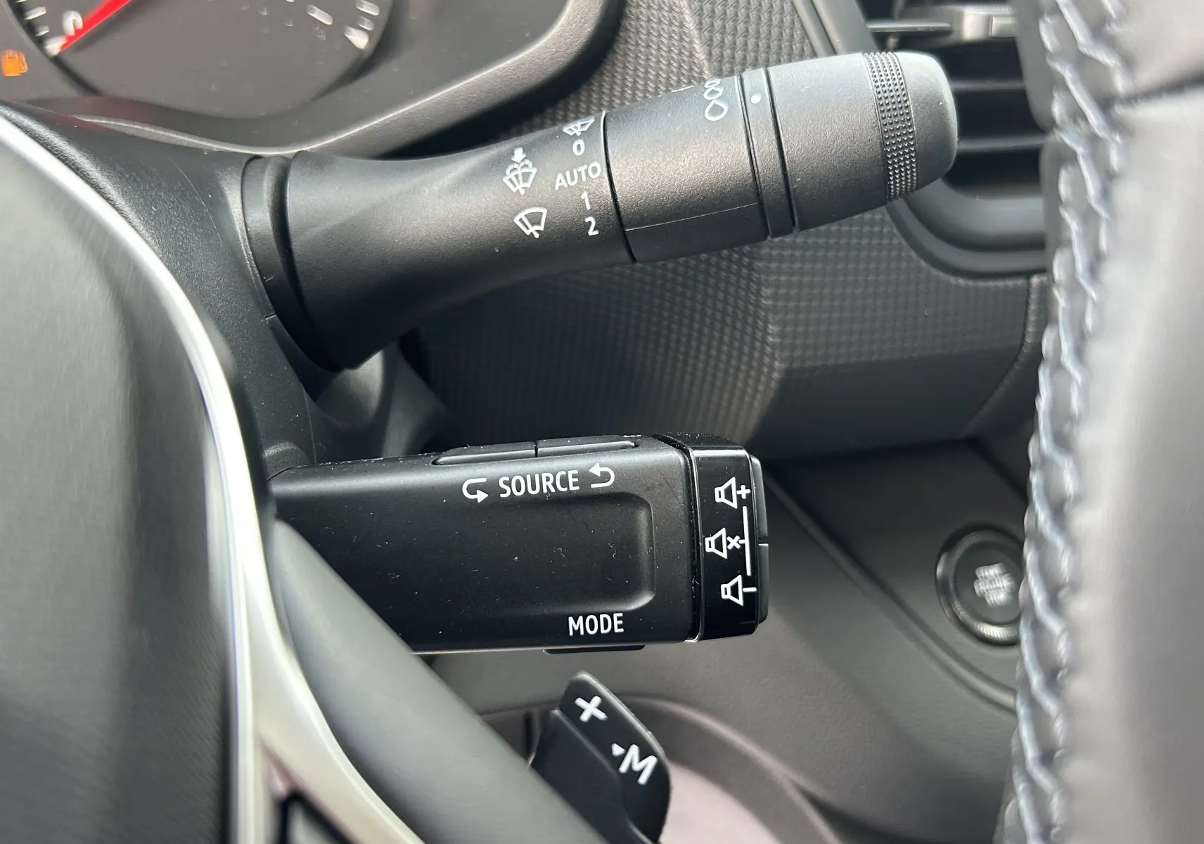 Gros plan sur les commandes au volant du Renault Trafic Fourgon L1H1 2025, avec palettes de changement de vitesse visibles.