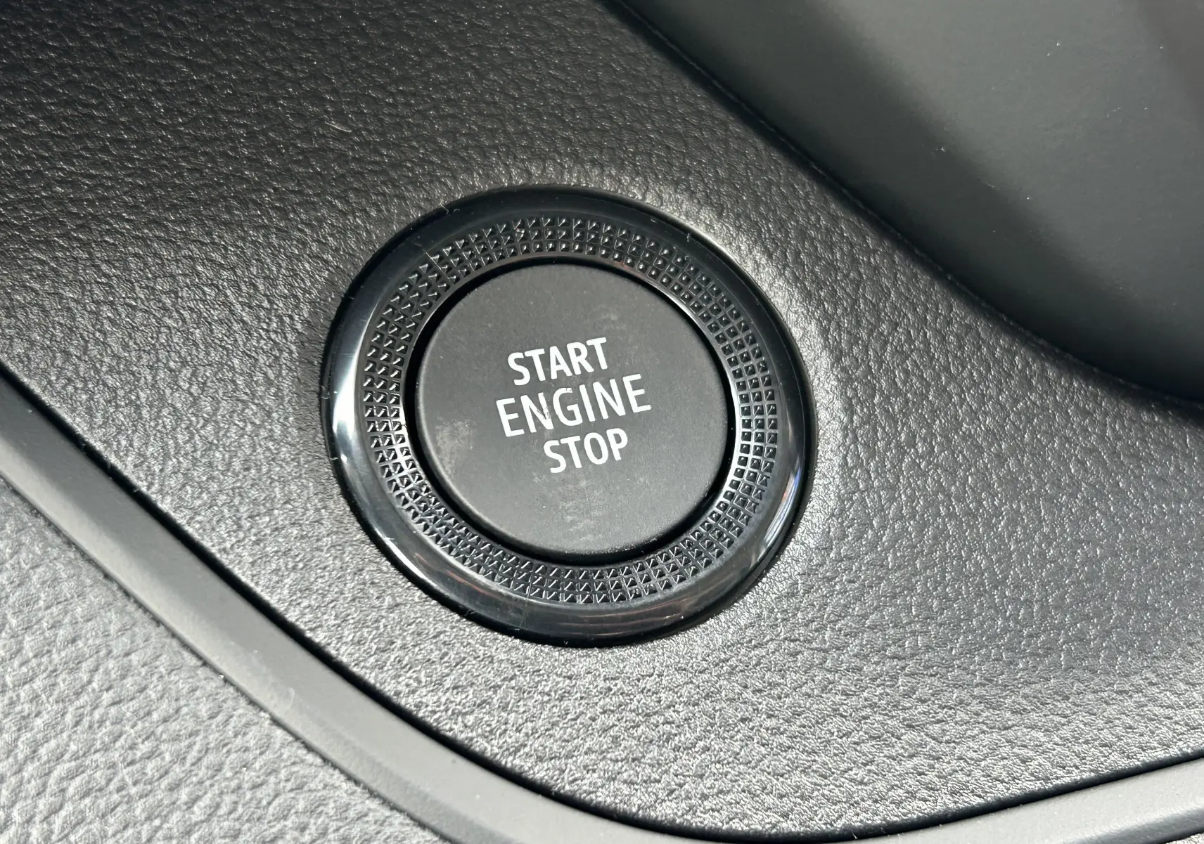 Gros plan sur le bouton Start Engine Stop noir intégré dans la console intérieure du Renault Trafic Fourgon 2025.
