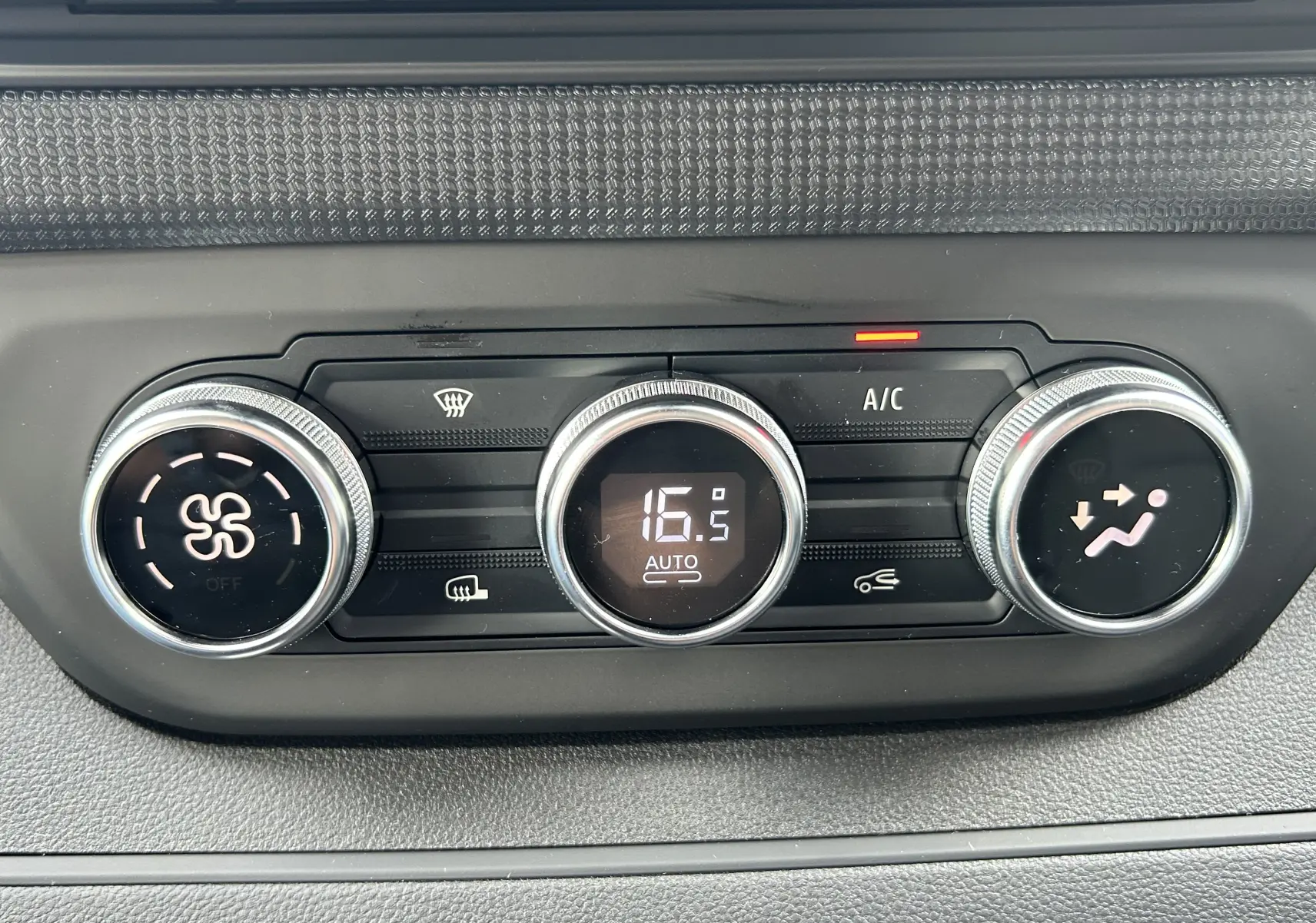 Gros plan sur la commande de climatisation automatique du Renault Trafic Fourgon blanc, affichant 16,5°C en mode auto.