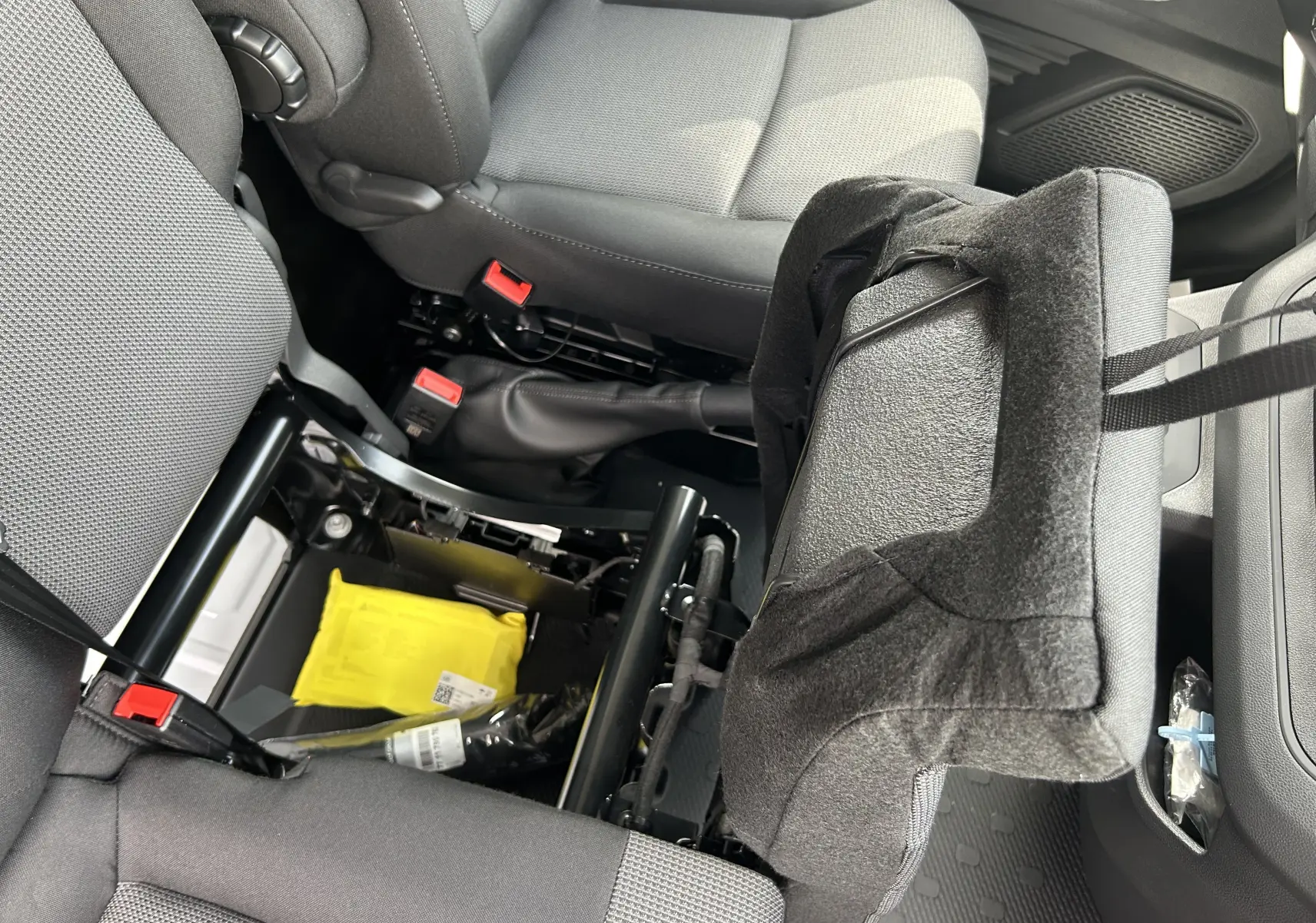 Vue intérieure rapprochée du siège passager avant relevé du Renault Trafic Fourgon L1H1 2025 avec tissu gris et espace de rangement visible.