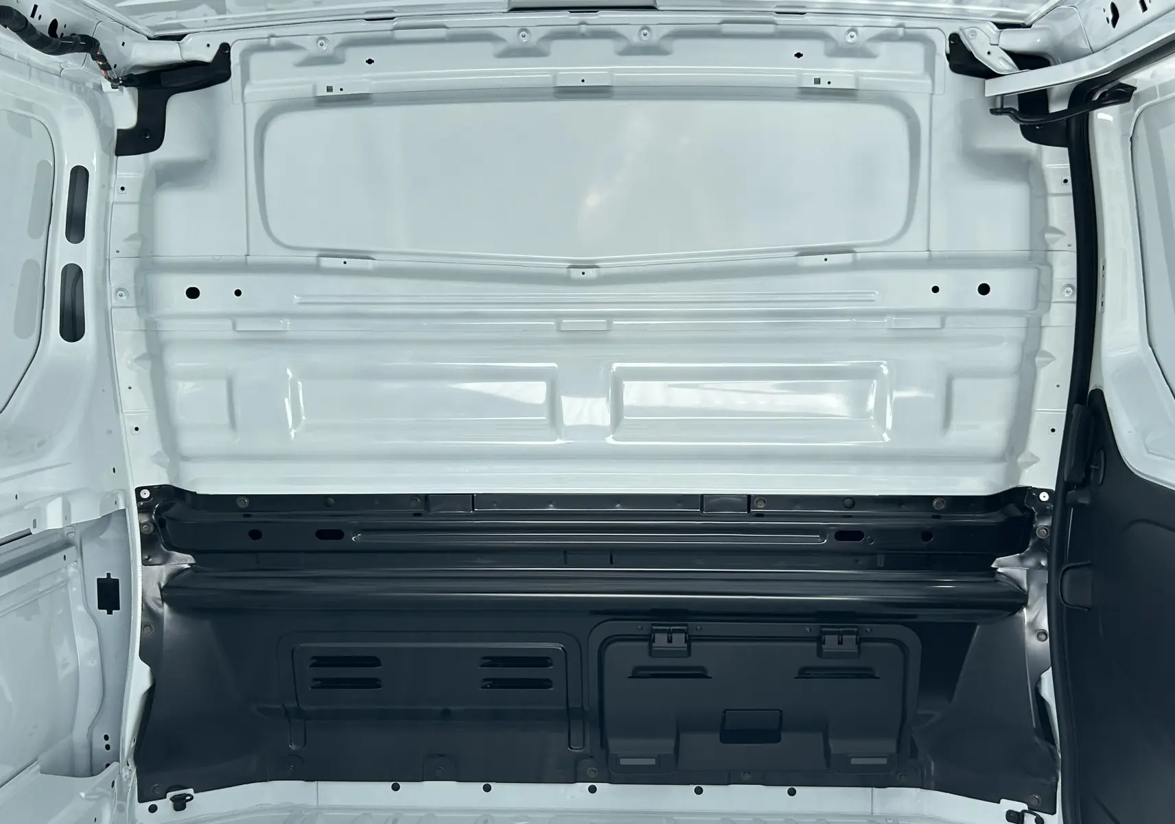 Vue intérieure du compartiment de chargement blanc glacier du Renault Trafic Fourgon L1H1 2025, montrant la cloison tôlée arrière.