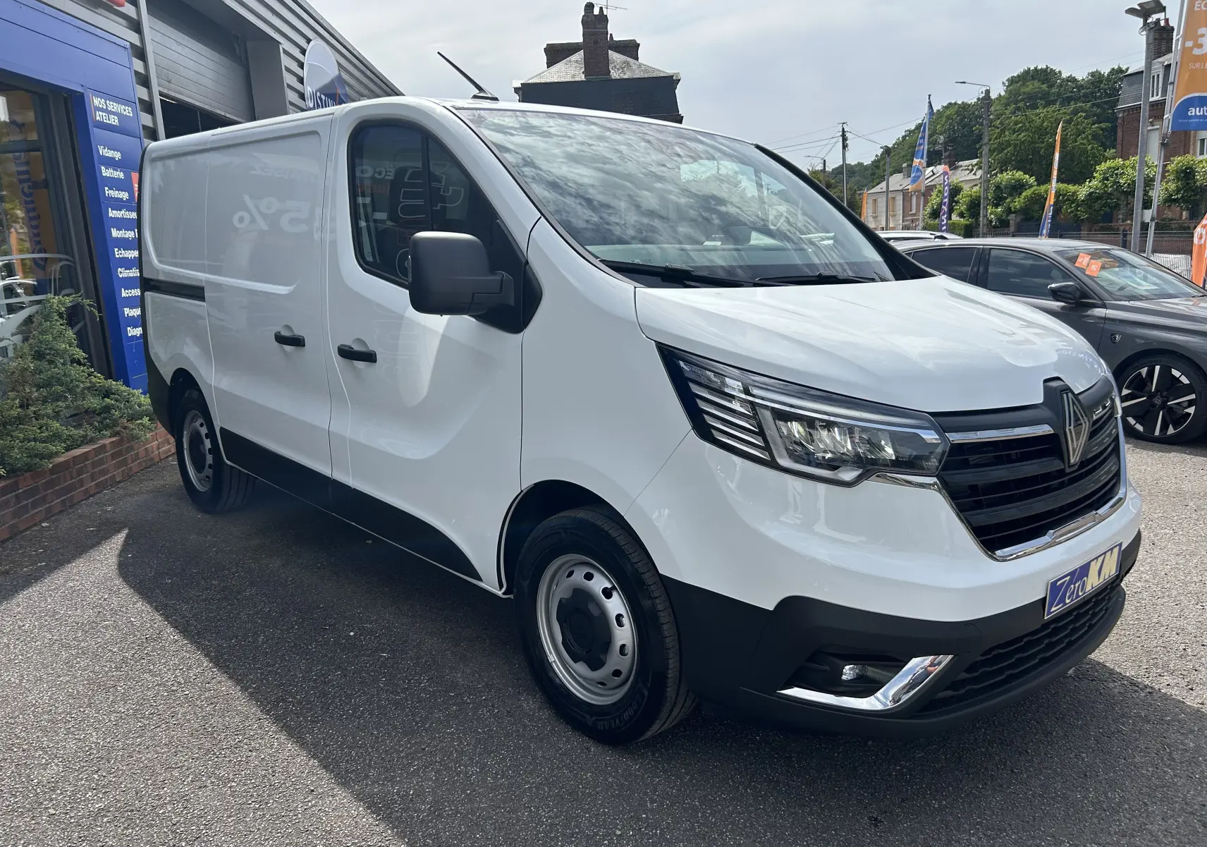 Renault Trafic Fourgon blanc glacier vu en 3/4 avant droit, avec calandre noire et projecteurs modernes.