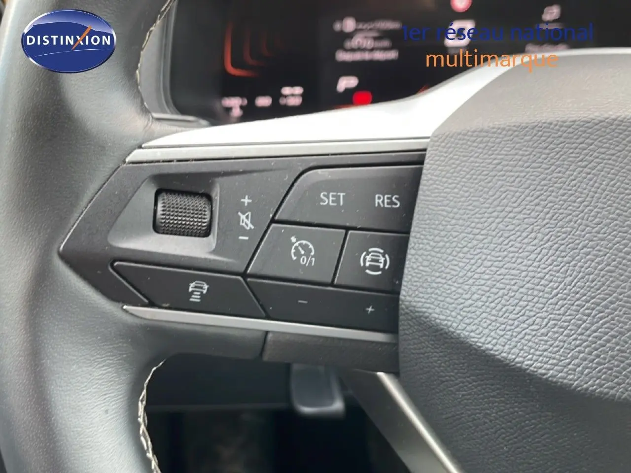 Gros plan sur les commandes au volant du SEAT Arona 2025, mettant en valeur les boutons de régulateur de vitesse et d’assistance.