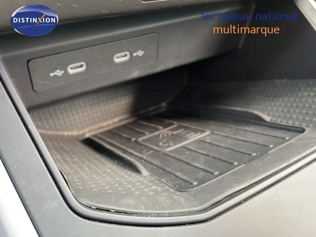 Détail de la console centrale avec ports USB-C et surface de recharge sans fil du SEAT Arona rouge désir métal toit noir.