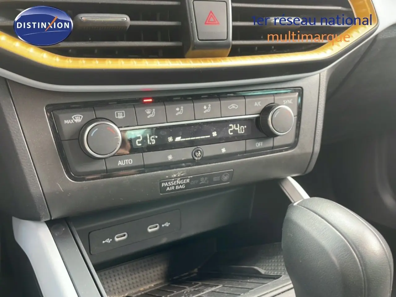 Gros plan sur la console centrale et la commande de climatisation du SEAT Arona rouge désir métal avec toit noir.