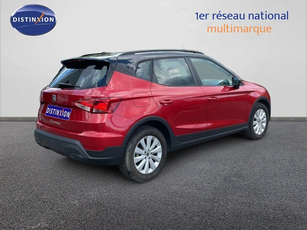 SEAT Arona rouge désir métal avec toit noir, vue 3/4 arrière côté droit sur fond neutre.