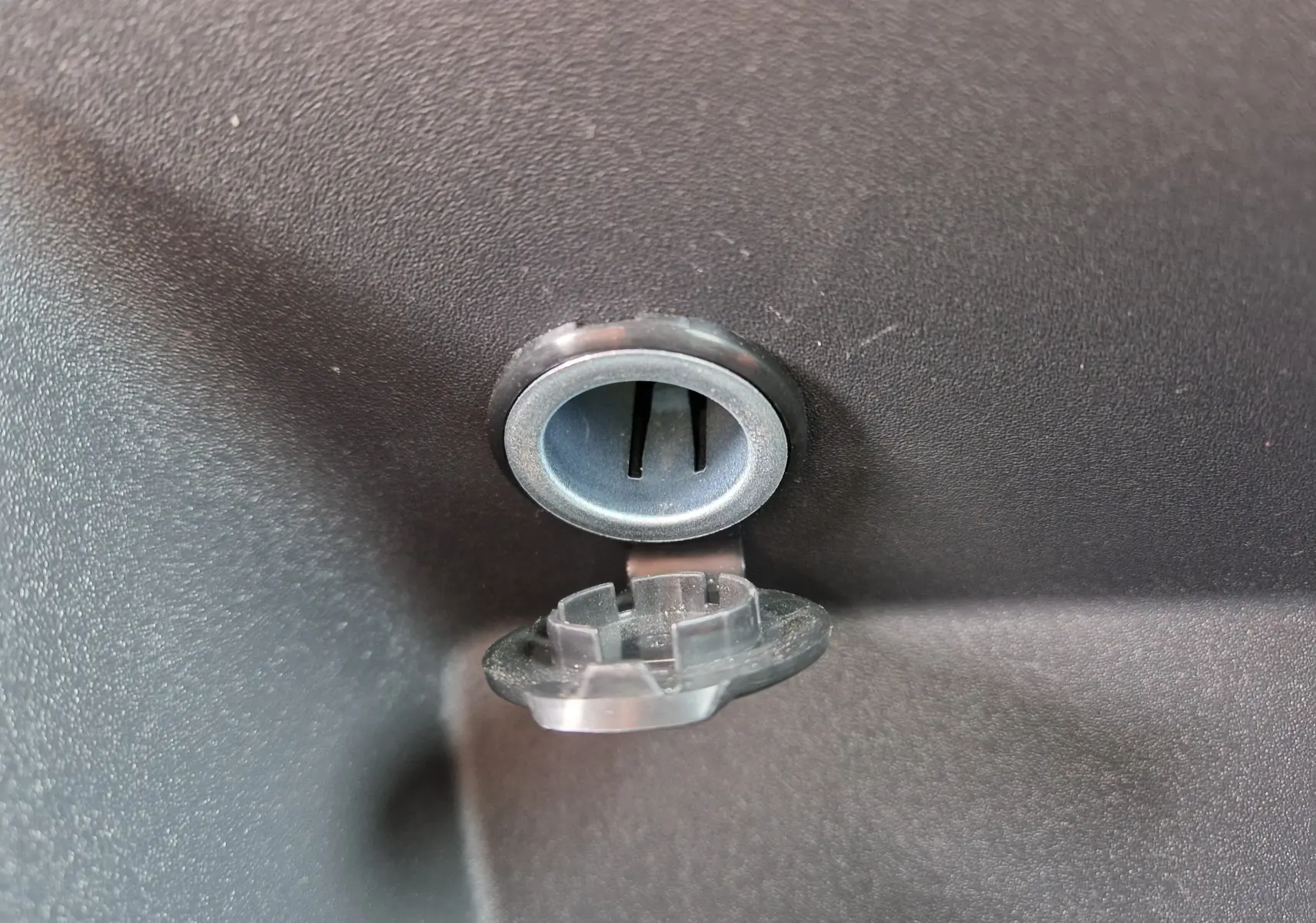 Gros plan sur la prise 12V avec cache ouvert dans l’habitacle du Volkswagen Caddy Cargo blanc 2023.