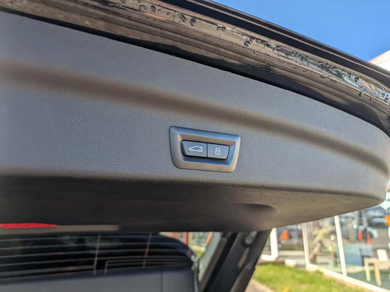 Bouton de fermeture électrique du hayon sur la partie intérieure du coffre d’un BMW X1 noir.