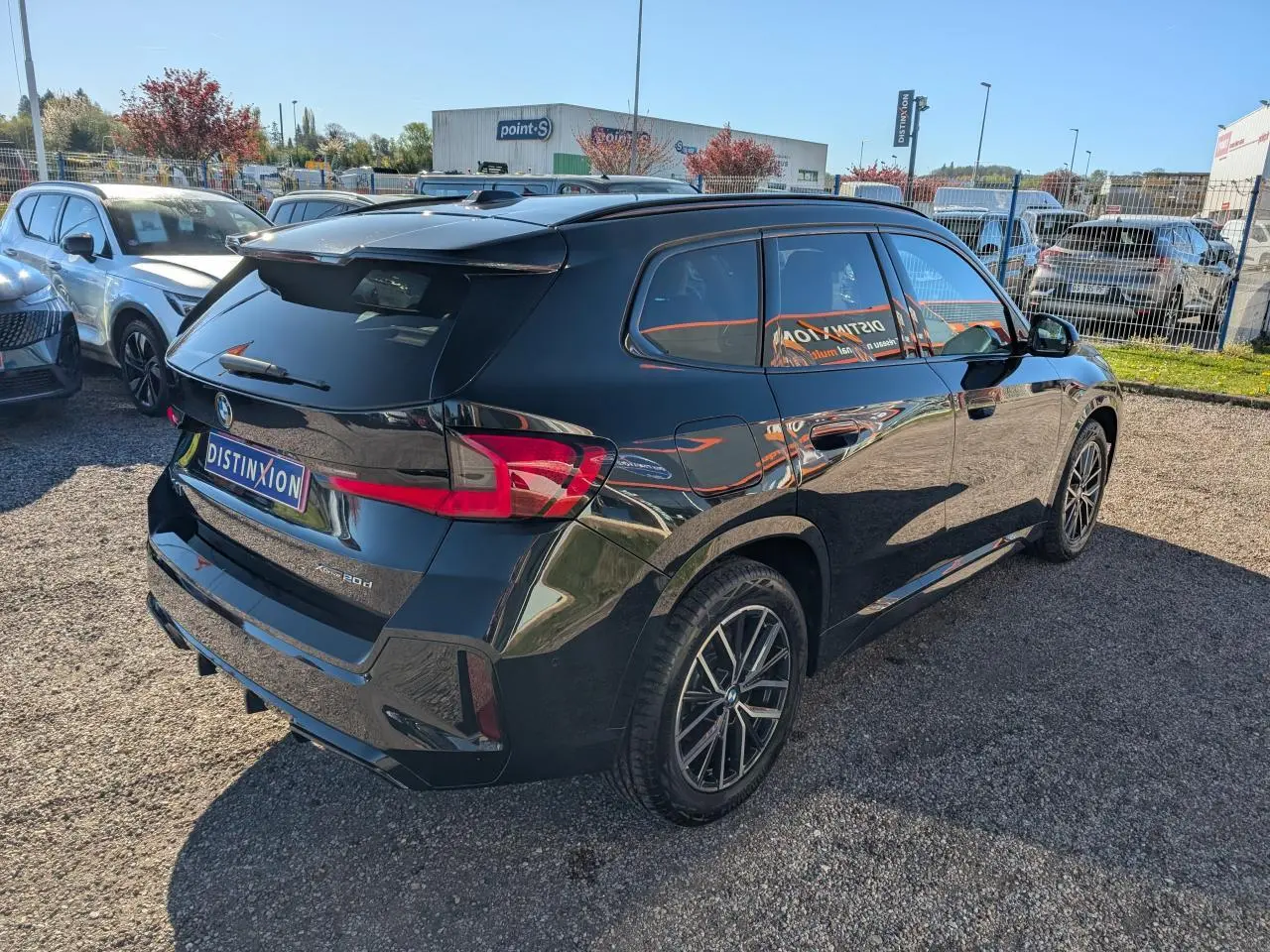 BMW X1 XDrive 20d noir vue 3/4 arrière droit, jantes alliage bicolores et vitres teintées.