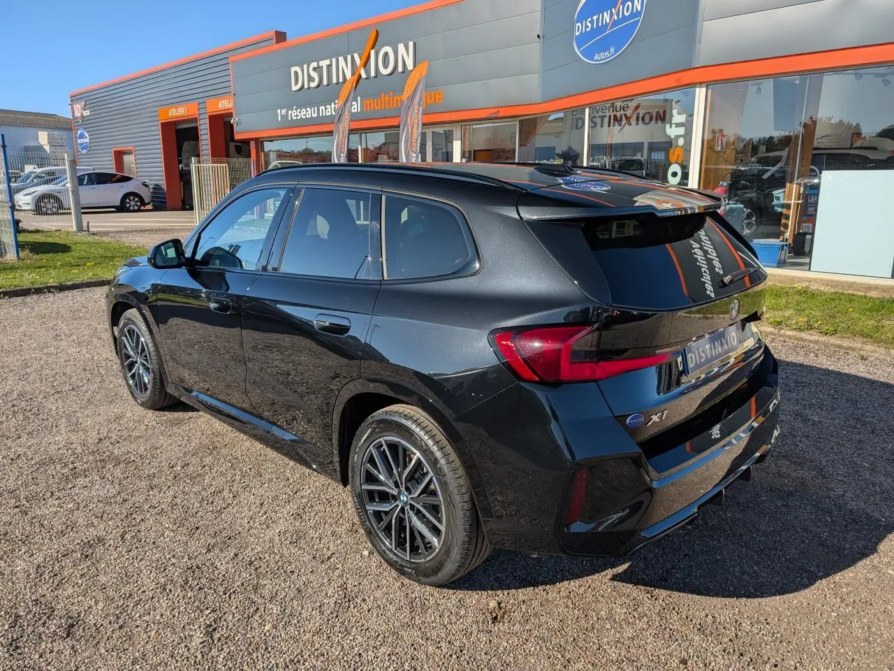 BMW X1 XDrive 20d M Sport noir 3/4 arrière droit, jantes alliage 18 pouces et feux LED arrière visibles.