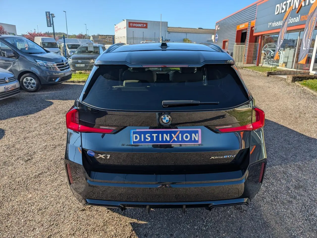 Vue arrière d’un BMW X1 noir métallisé avec feux LED horizontaux et logo BMW bien visible.