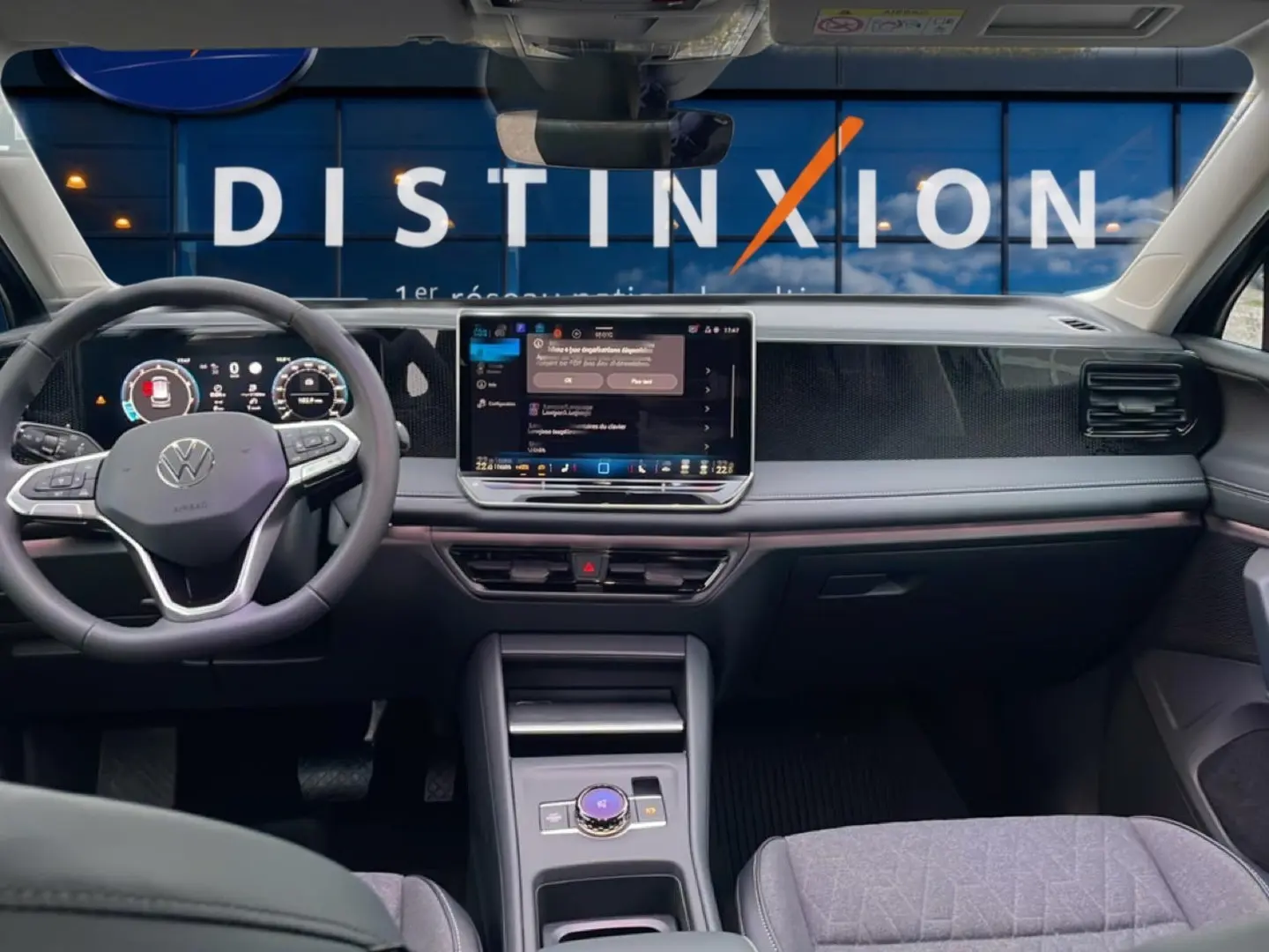 Vue intérieure avant du Volkswagen Tiguan 2025 noir, tableau de bord moderne avec écran tactile central et volant multifonction.