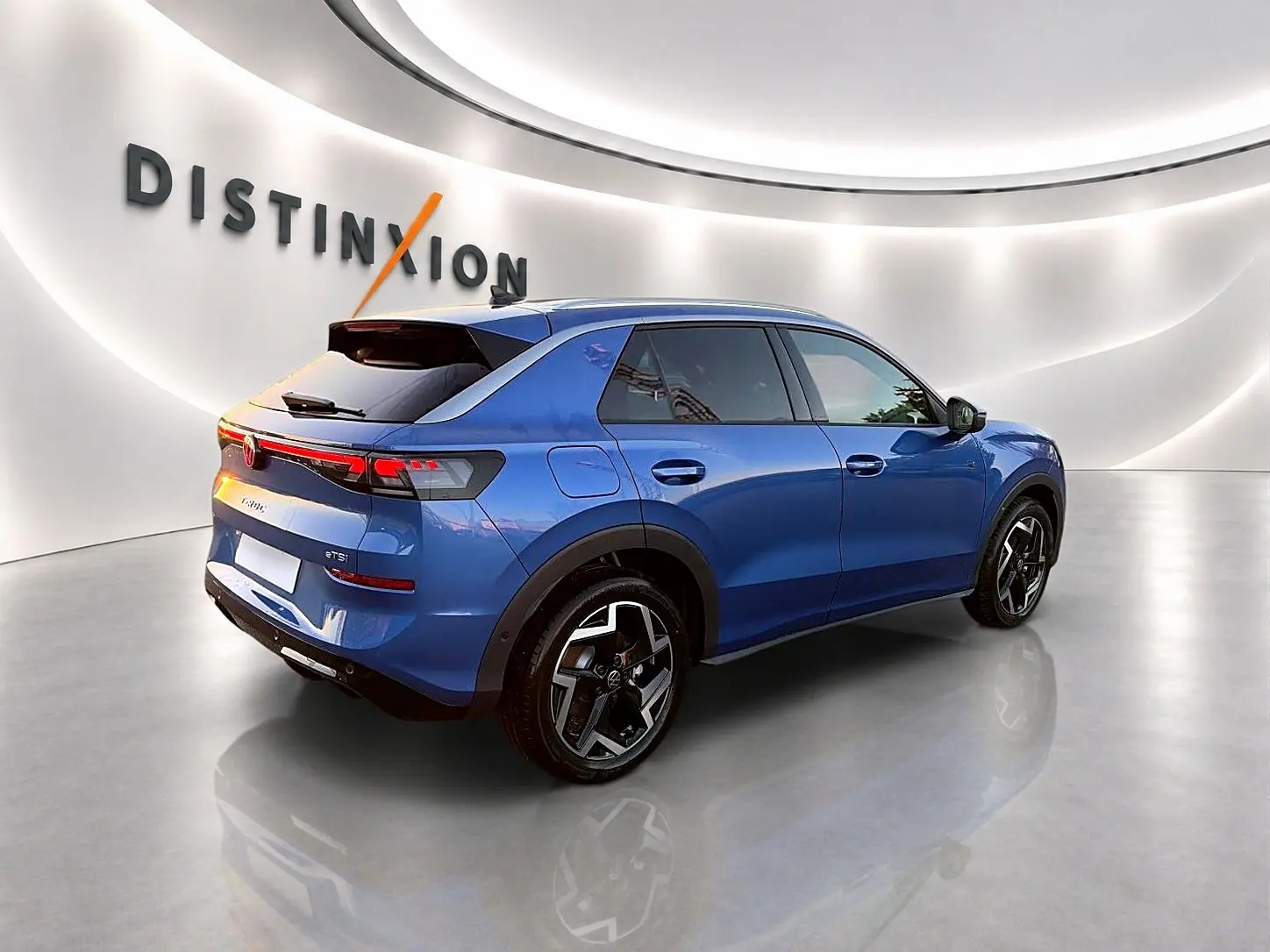 Volkswagen T-Roc bleu céleste en 3/4 arrière droit, avec jantes alu noires et toit noir brillant.