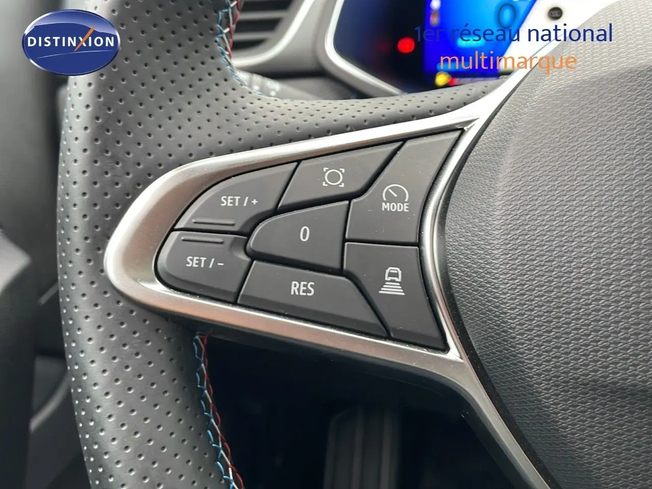 Gros plan sur les commandes du volant perforé de la Renault SYMBIOZ gris Rafale, version hybride 2025.