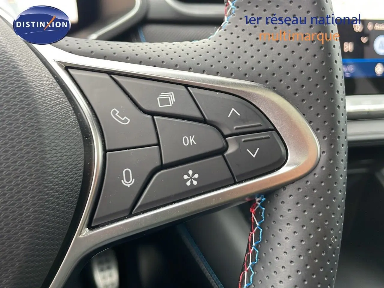 Gros plan sur les commandes multifonctions du volant en cuir perforé noir du Renault Symbioz gris Rafale Metal.