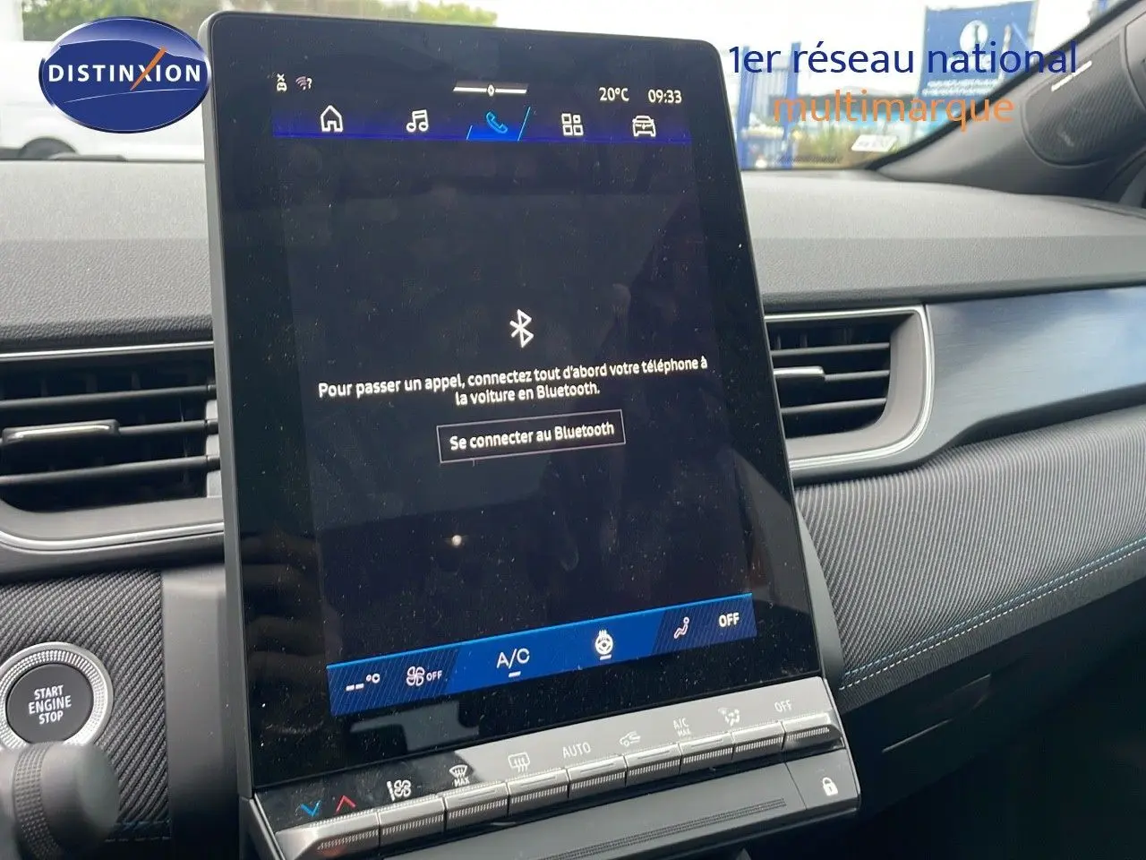 Écran tactile central allumé dans l'habitacle du Renault Symbioz gris Rafale, avec tableau de bord et bouton start visibles.