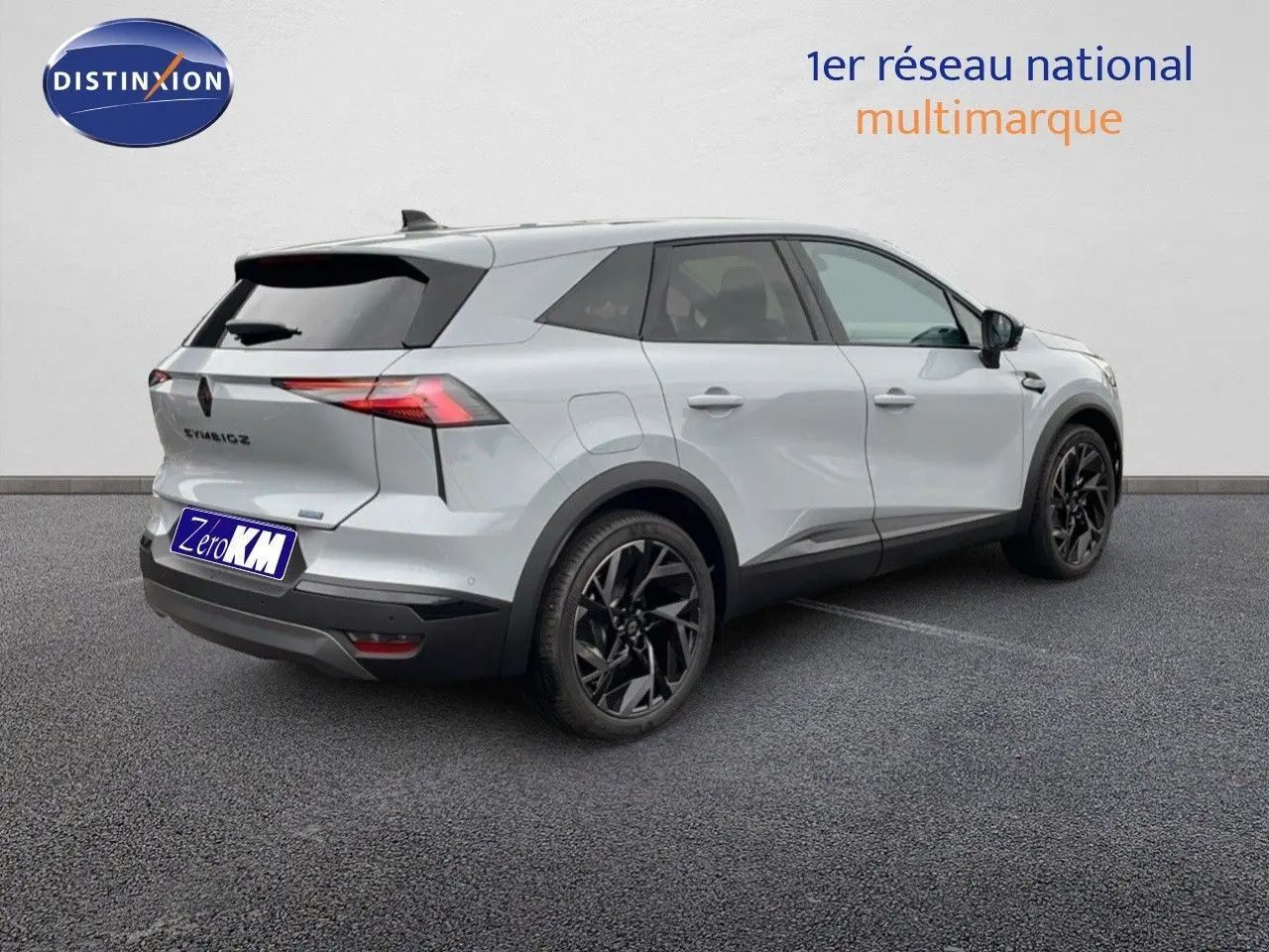 Vue 3/4 arrière droite d'un Renault Symbioz gris Rafale métallisé avec jantes noires et feux arrière LED distinctifs.