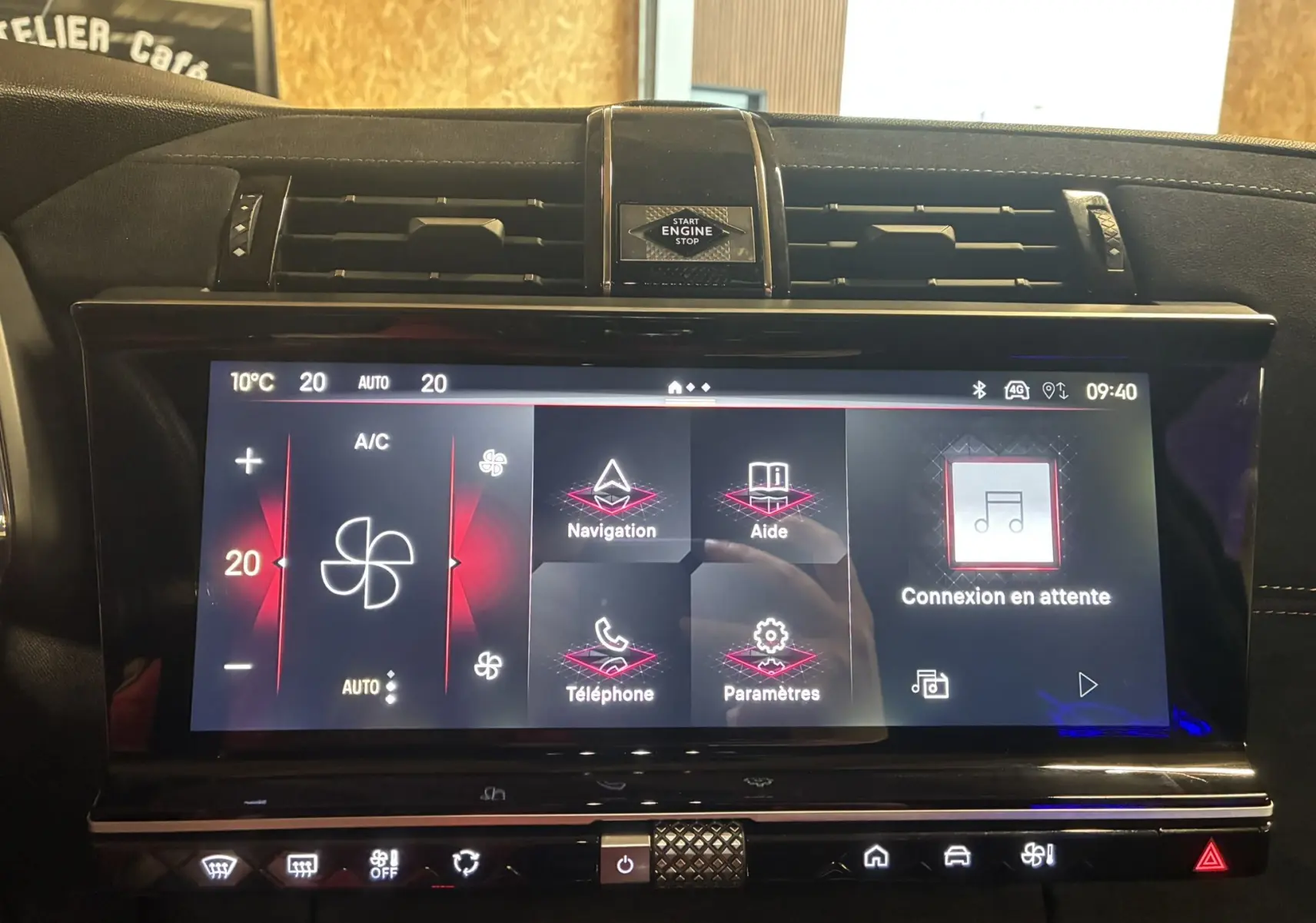 Vue rapprochée de l’écran tactile central du DS7 gris 2024, affichant les commandes de climatisation et navigation.