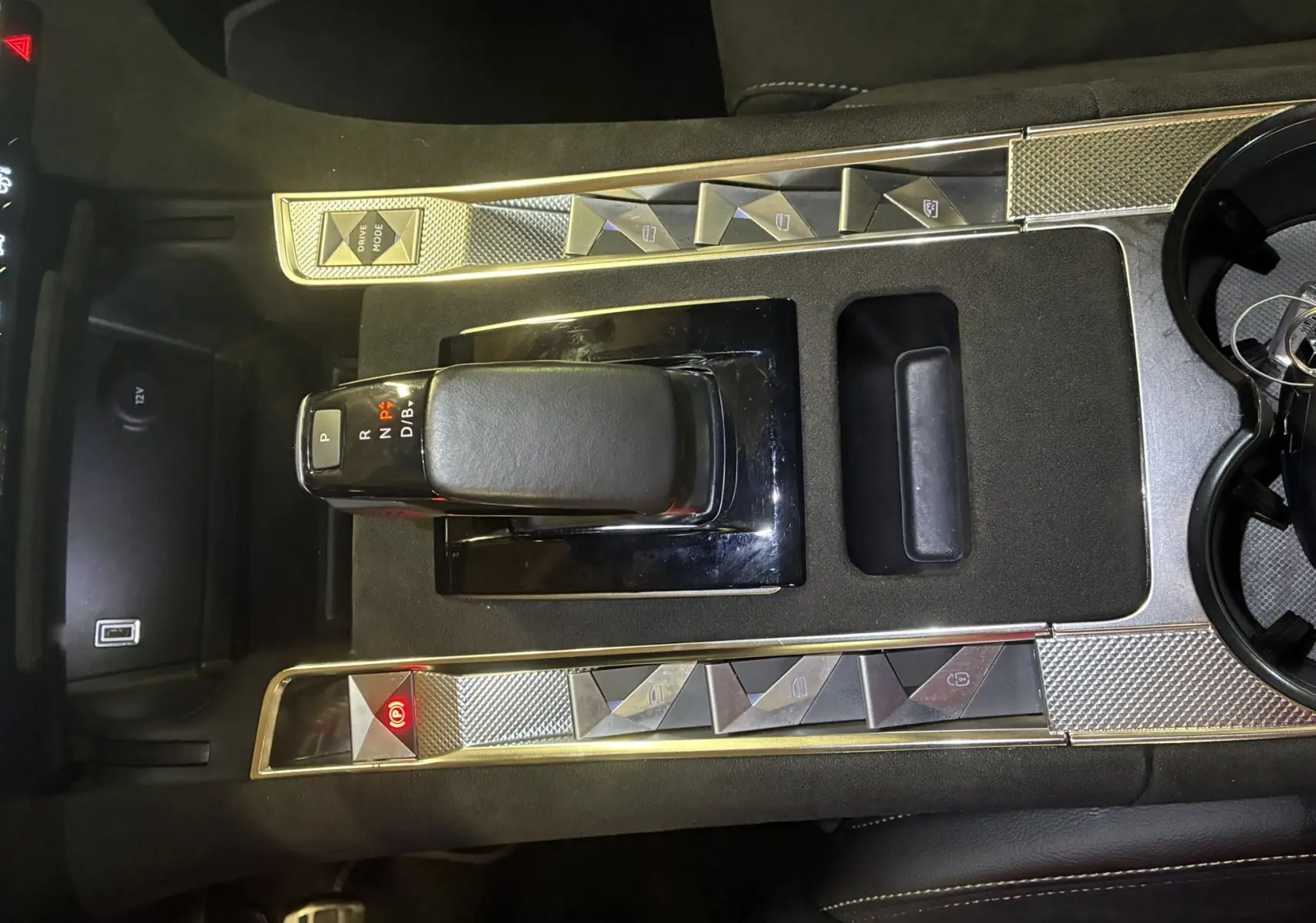 Vue rapprochée de la console centrale noire du DS7 E-TENSE 2024 avec levier de vitesse automatique et boutons argentés.