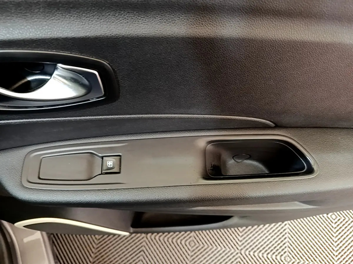 Détail de la poignée intérieure et commande de vitre côté droit du Renault Captur gris foncé, version Business 2018.