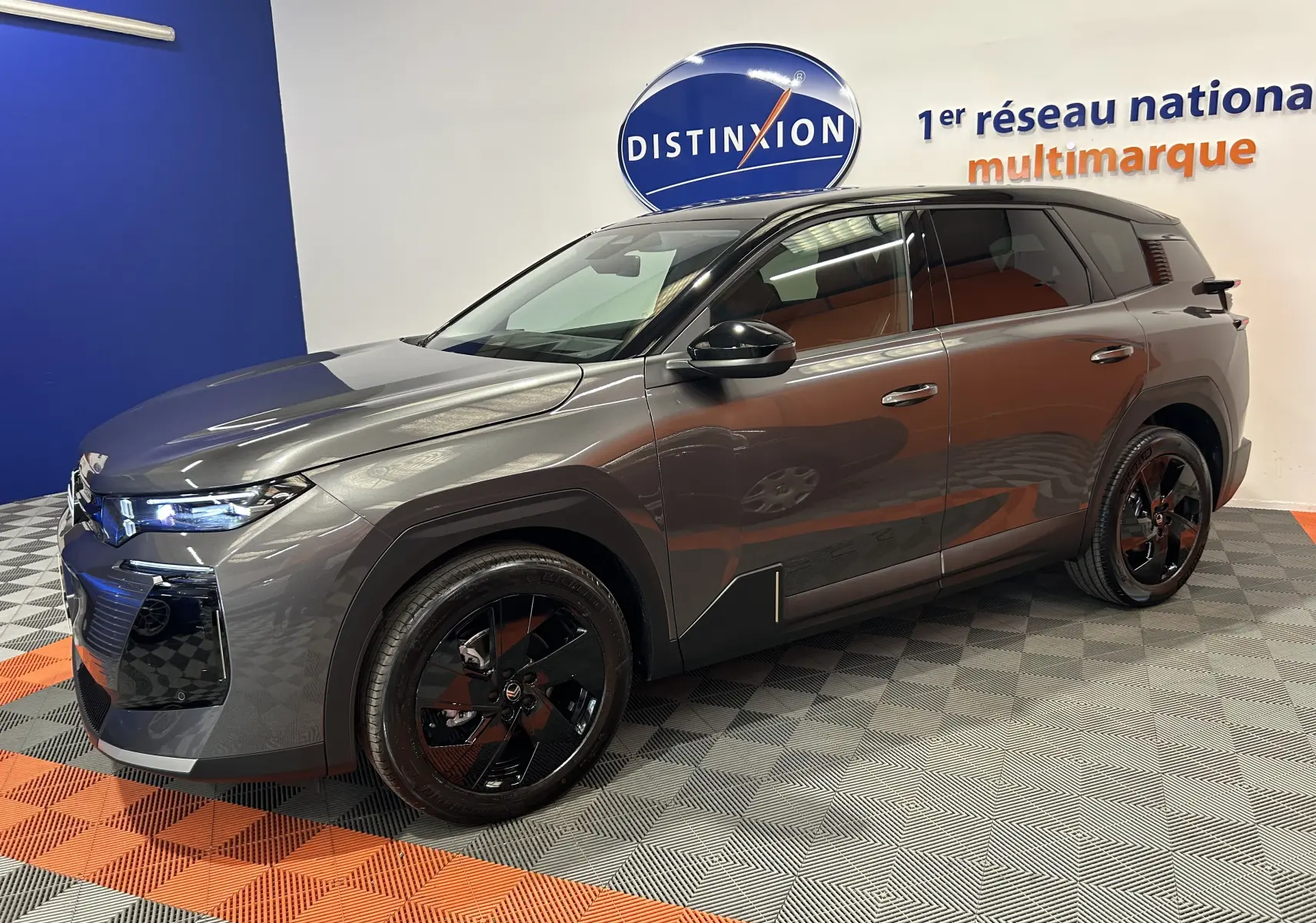 Vue 3/4 avant droite du Citroën C5 Aircross II Hybrid gris Platinium avec toit noir et jantes noires brillantes.