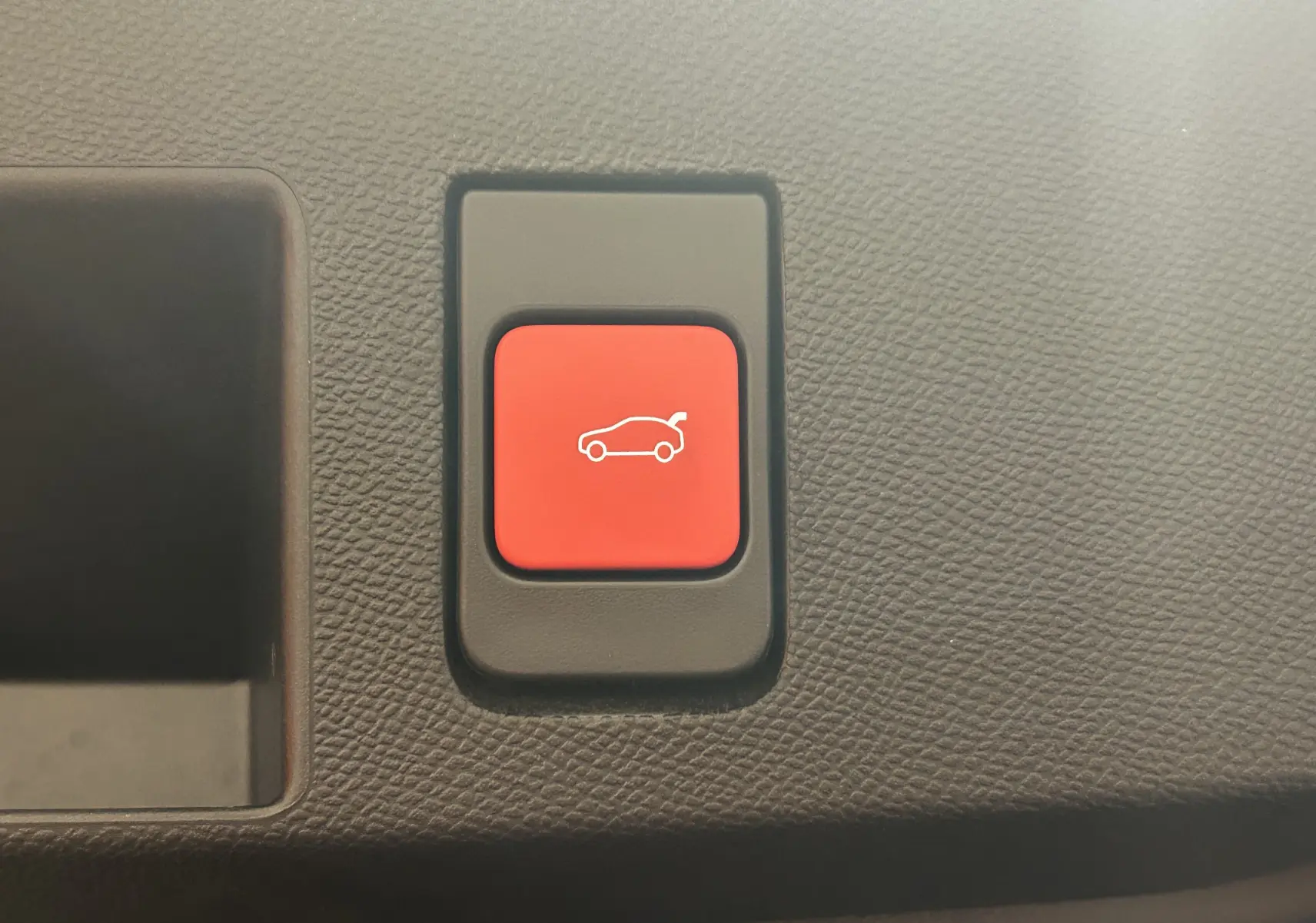Bouton rouge d'ouverture du coffre sur tableau de bord texturé du Citroën C5 Aircross II Hybrid 2026.
