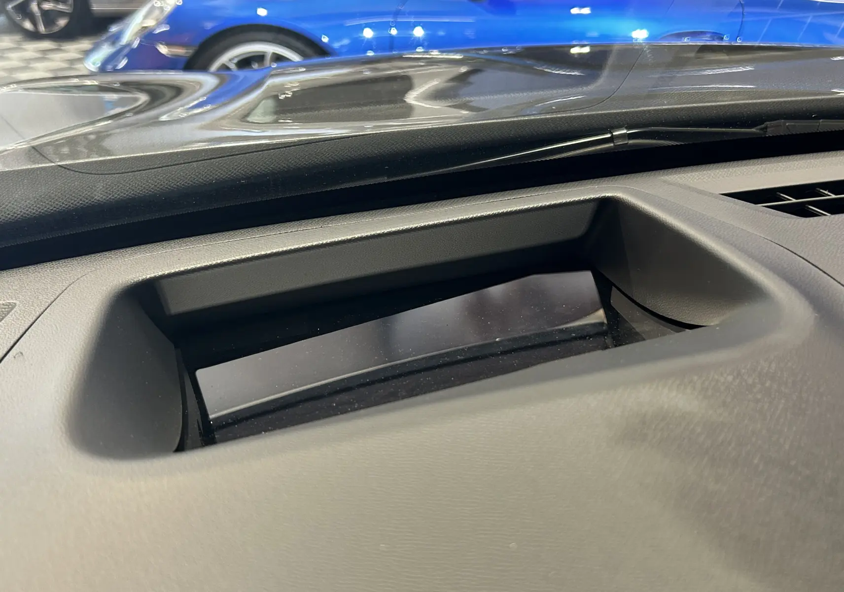 Vue rapprochée de l'écran escamotable du tableau de bord d'un Citroën C5 Aircross gris Platinium, avec reflet bleu en arrière-plan.