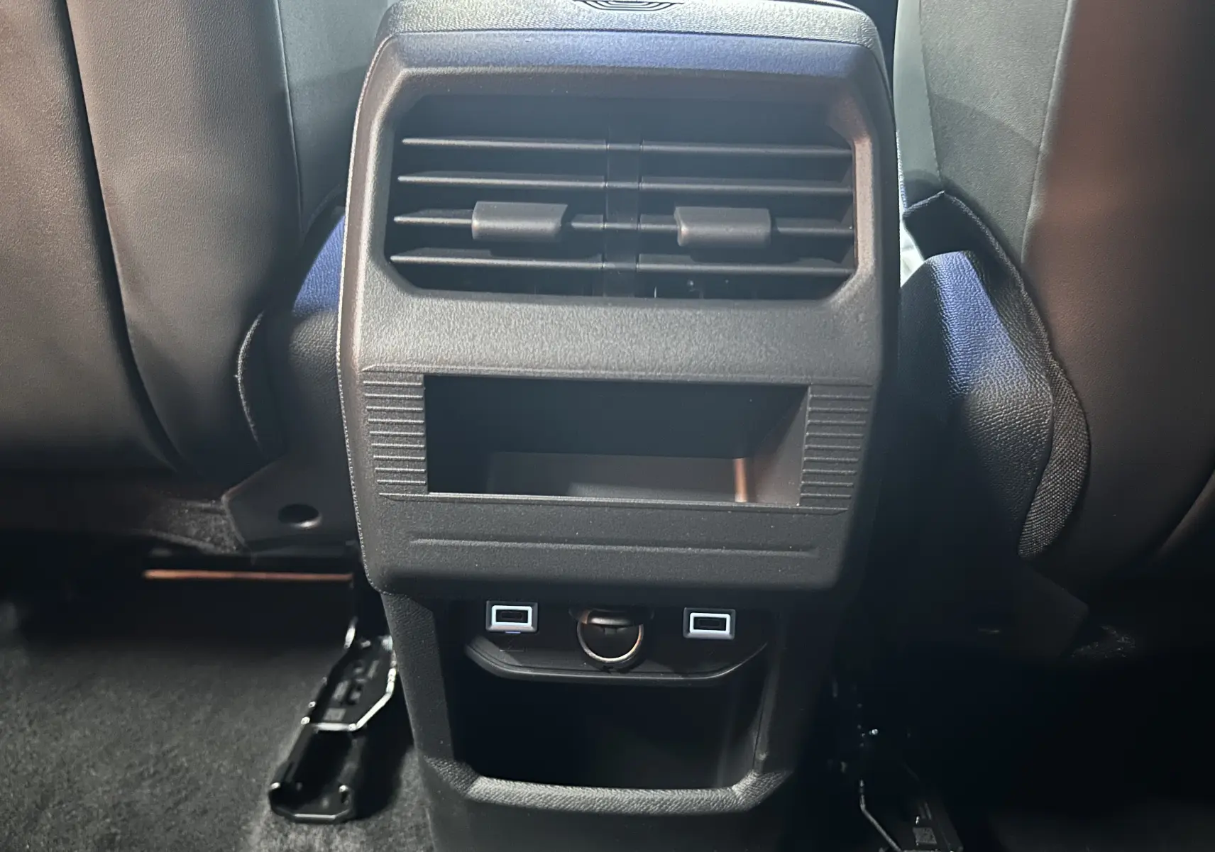 Vue rapprochée de la console arrière noire du Citroën C5 Aircross II Hybrid avec bouches d’aération et ports USB.