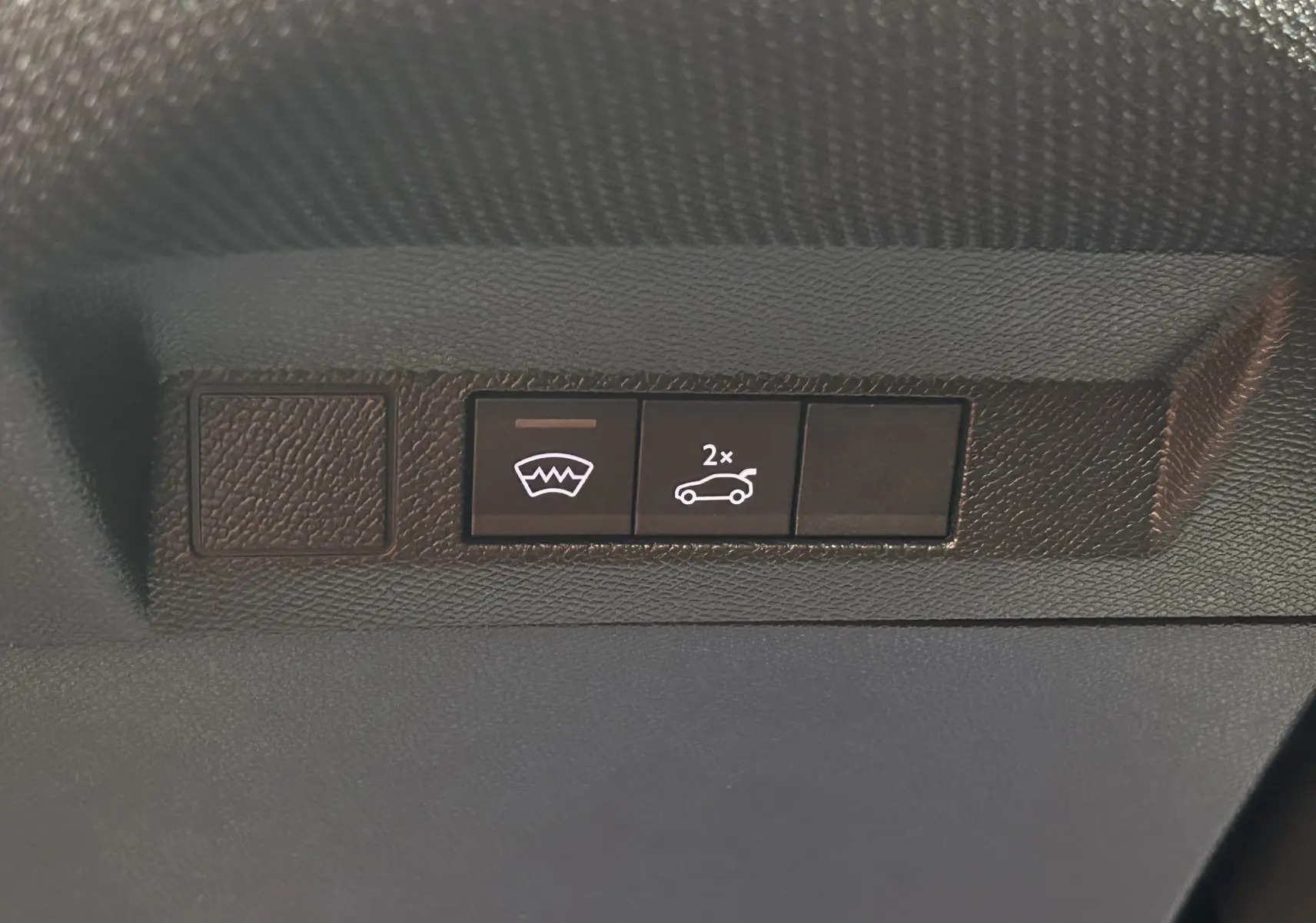 Boutons de commande du hayon électrique et du pare-brise chauffant sur le tableau de bord d'une Citroën C5 Aircross gris Platinium.