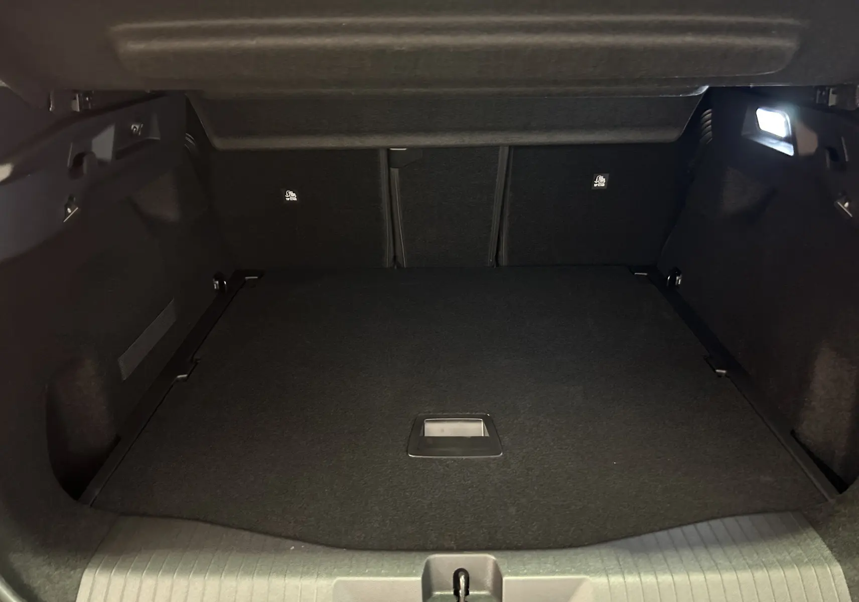 Coffre spacieux et vide du Citroën C5 Aircross II Max Hybrid 145, vu de l'intérieur arrière, revêtement noir.