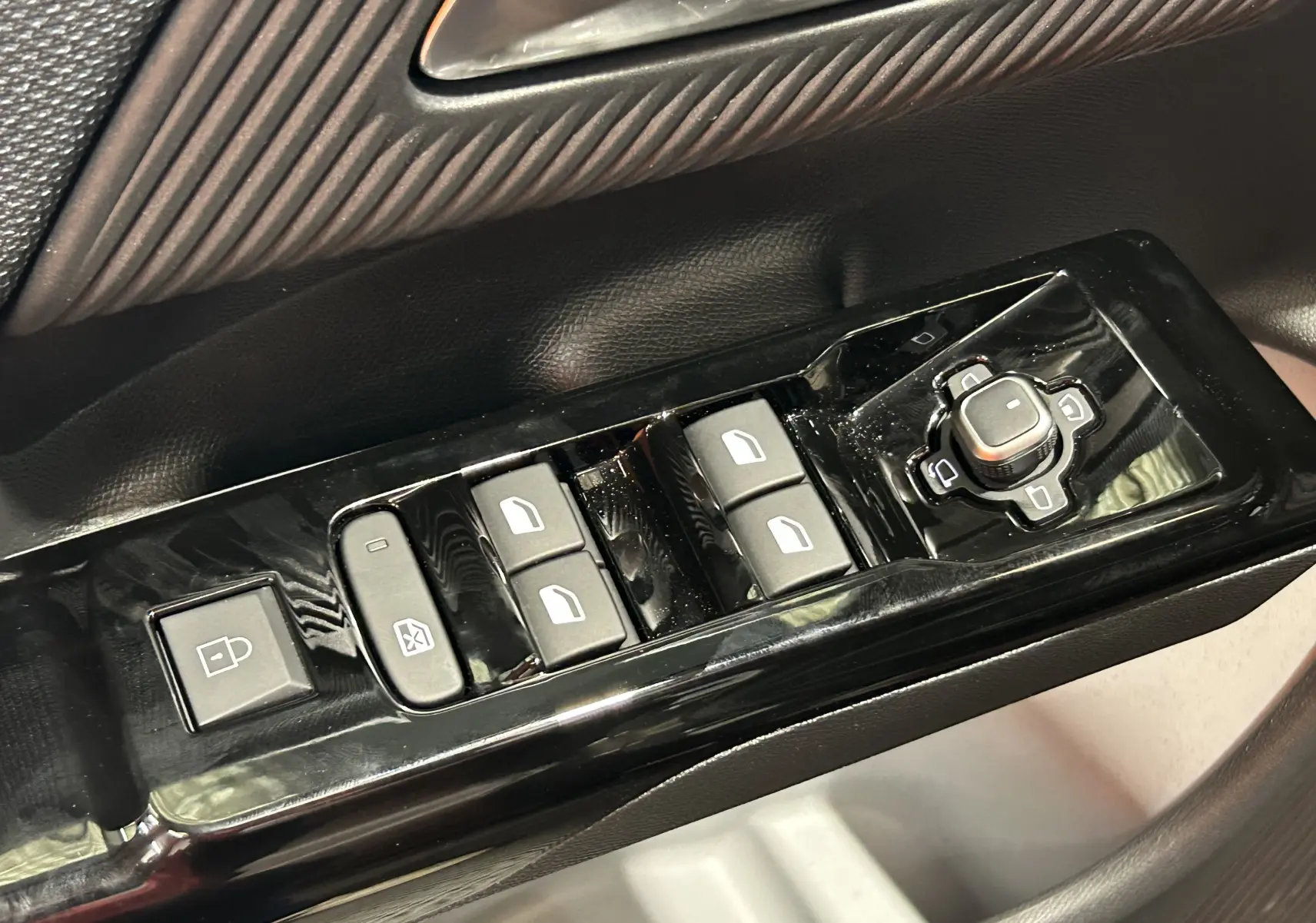 Gros plan sur les commandes de lève-vitres et rétroviseurs côté conducteur du Citroën C5 Aircross II Hybrid gris Platinium.