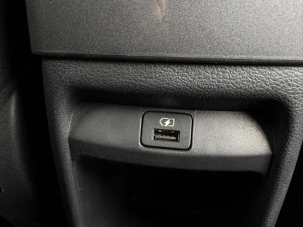 Prise USB de recharge intégrée dans la console centrale d'une Nissan Juke blanc perle 2024.