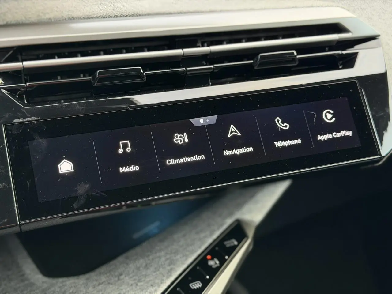 Gros plan sur l'écran tactile panoramique 21'' du Peugeot 3008 Hybrid blanc, affichant les options média, climatisation et navigation.