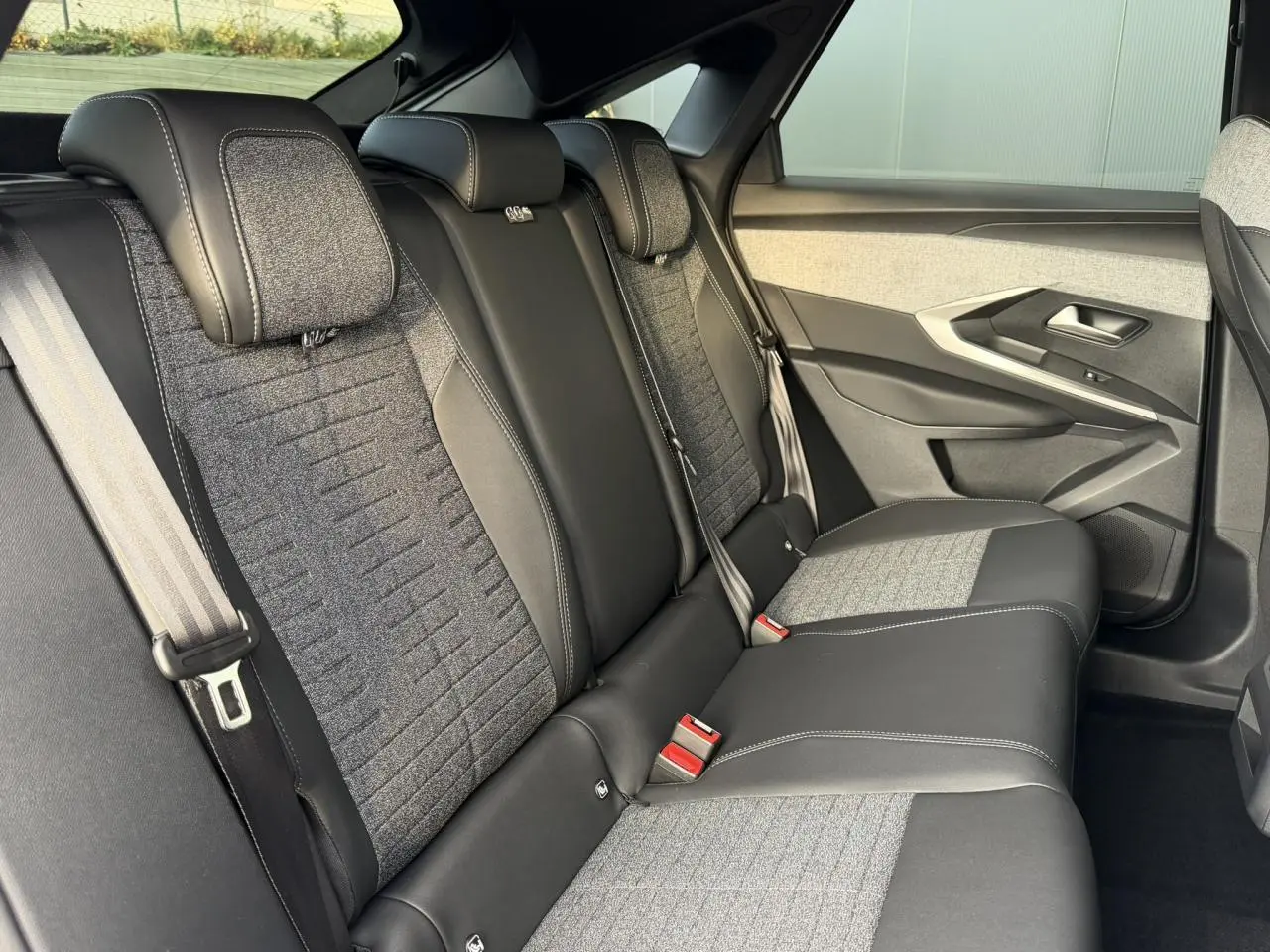 Vue côté droit de la banquette arrière bicolore tissu et cuir du Peugeot 3008 Hybrid 145 Allure 2025.