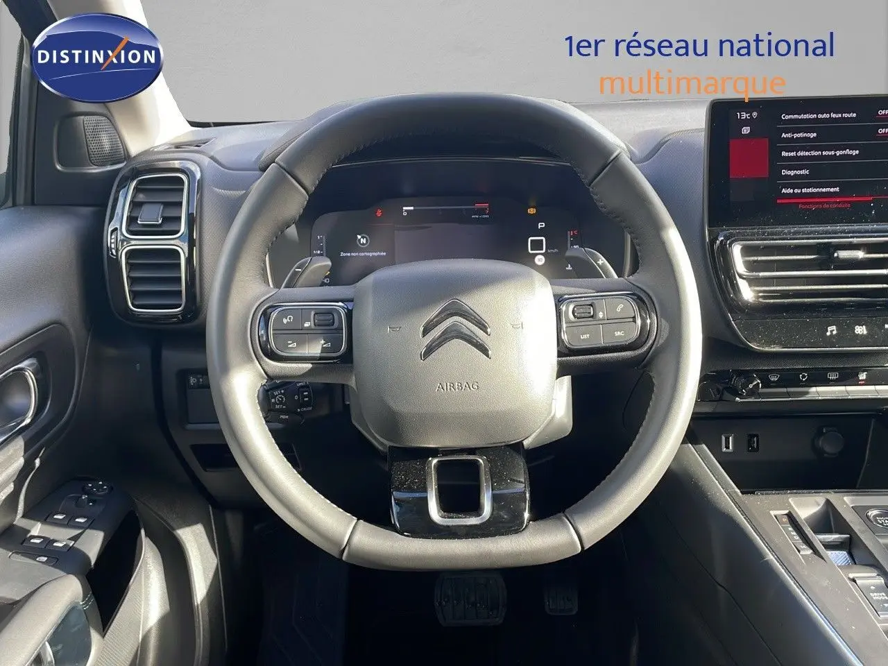 Vue centrée sur le volant cuir noir du Citroën C5 Aircross 2025 avec tableau de bord digital et écran tactile.