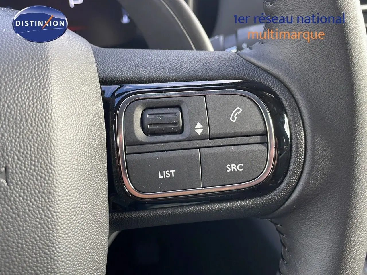 Gros plan sur les commandes au volant noir du Citroën C5 Aircross 2025, avec boutons de gestion d'appel et audio.