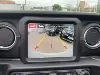 Écran de caméra de recul d'un Jeep Wrangler Unlimited vert métal 2023, affichant l'arrière du véhicule en hybride rechargeable.