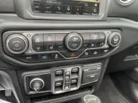 Gros plan sur la console centrale de la Jeep Wrangler Unlimited 2023, montrant les commandes climatisation et multimédia.
